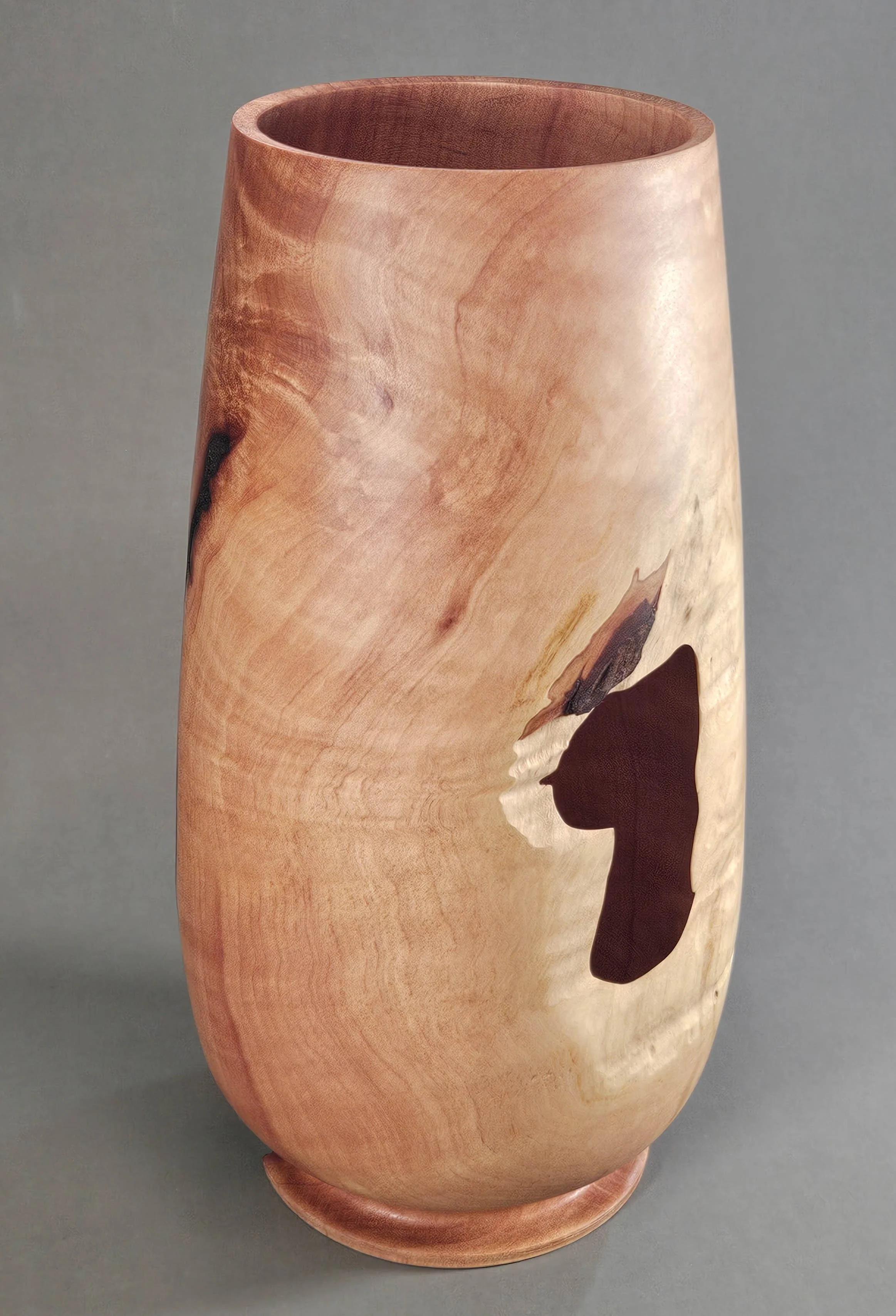 Vase made from Madrone wood this vase shows the beauty of figured wood from an old Madrone tree; partially open displaying the tree bark it's a unique decorative item.
