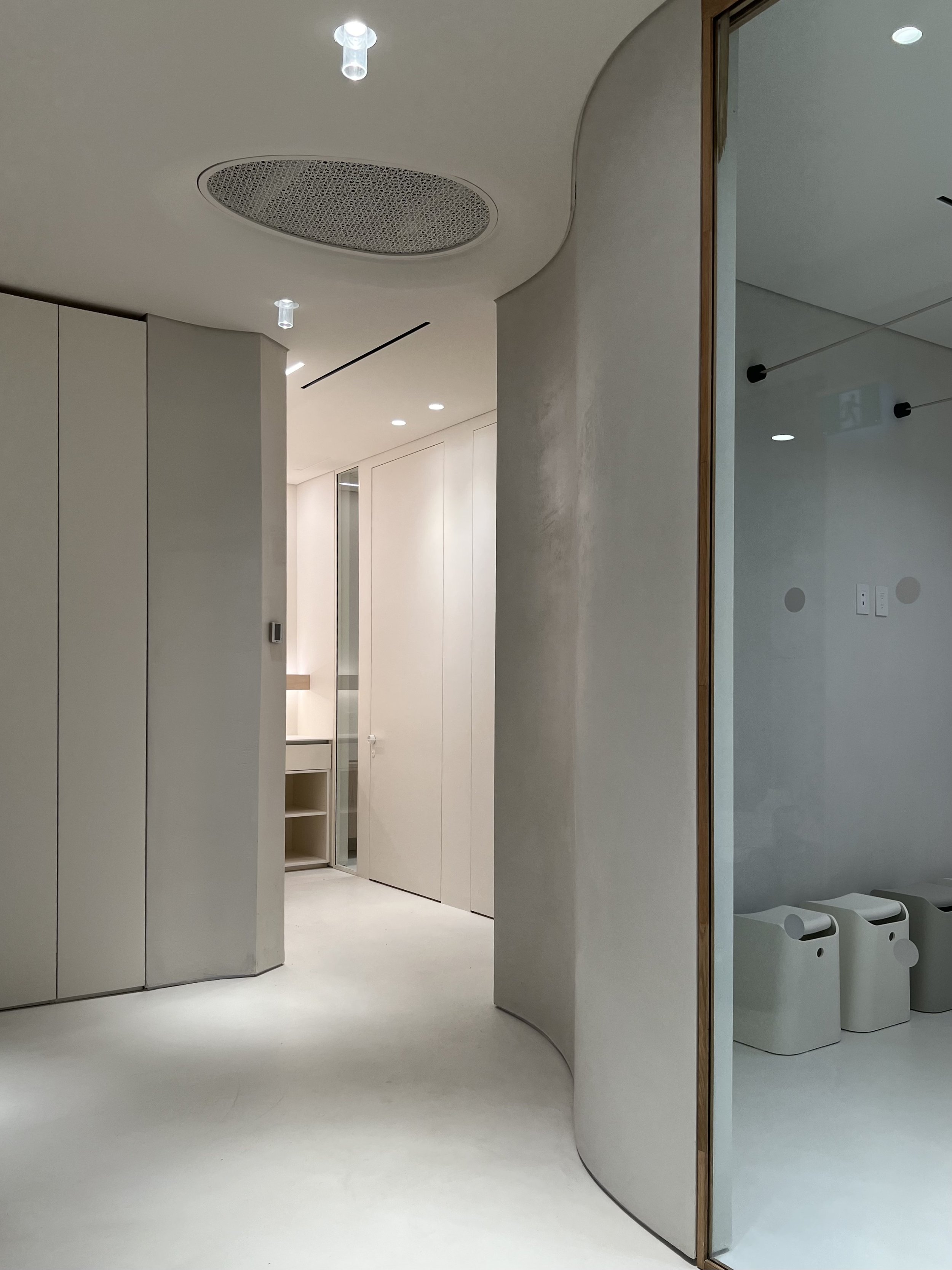 Wall Design | The undulating architectural story of the building is mirrored on interior walls. Walls with a three-dimensional wave design, highlighted with translucent bulb lighting, creates a dramatic and welcoming first impression.