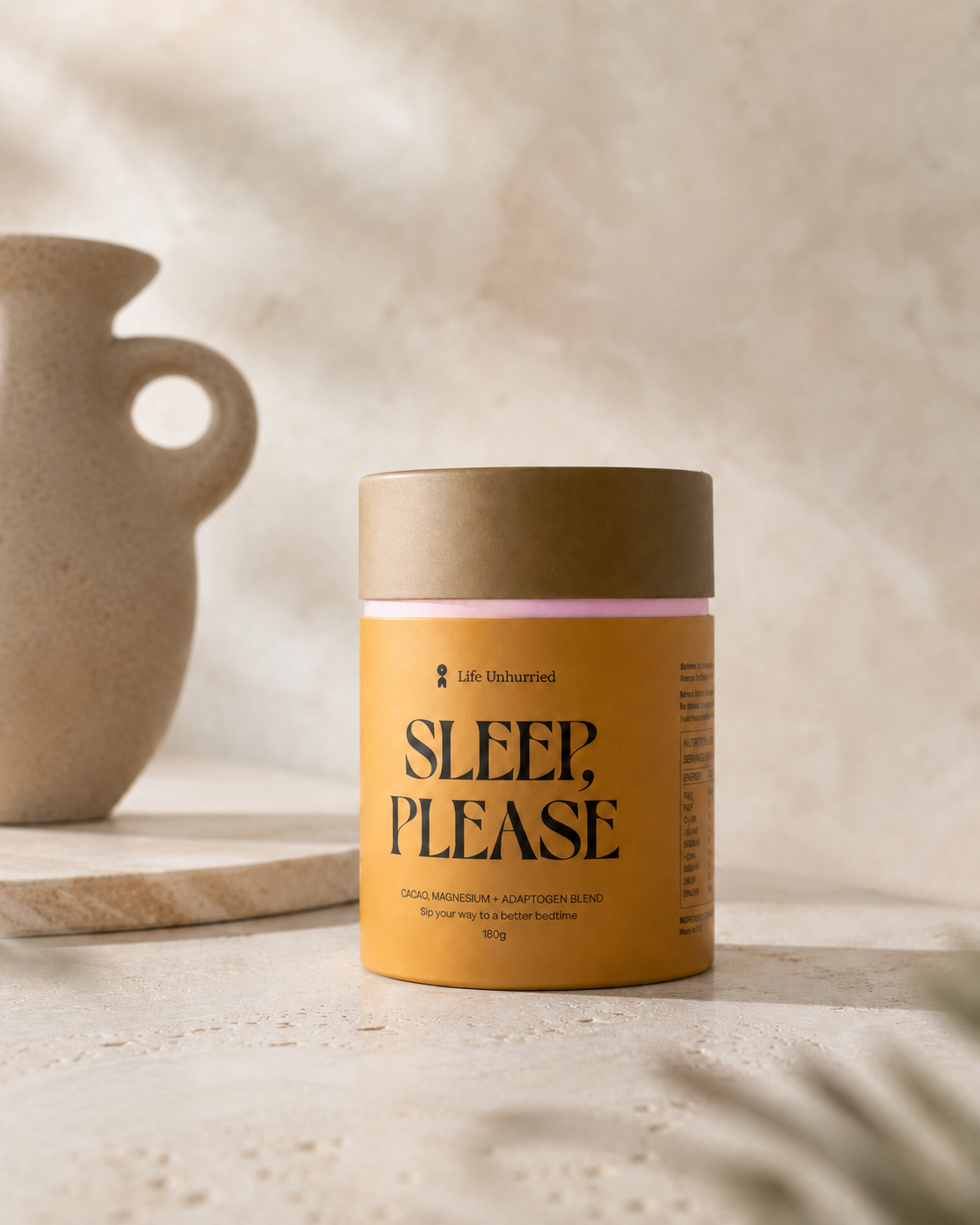 A container labeled 'Sleep, Please' with a beige lid, placed on a light-colored surface next to a speckled ceramic vase.