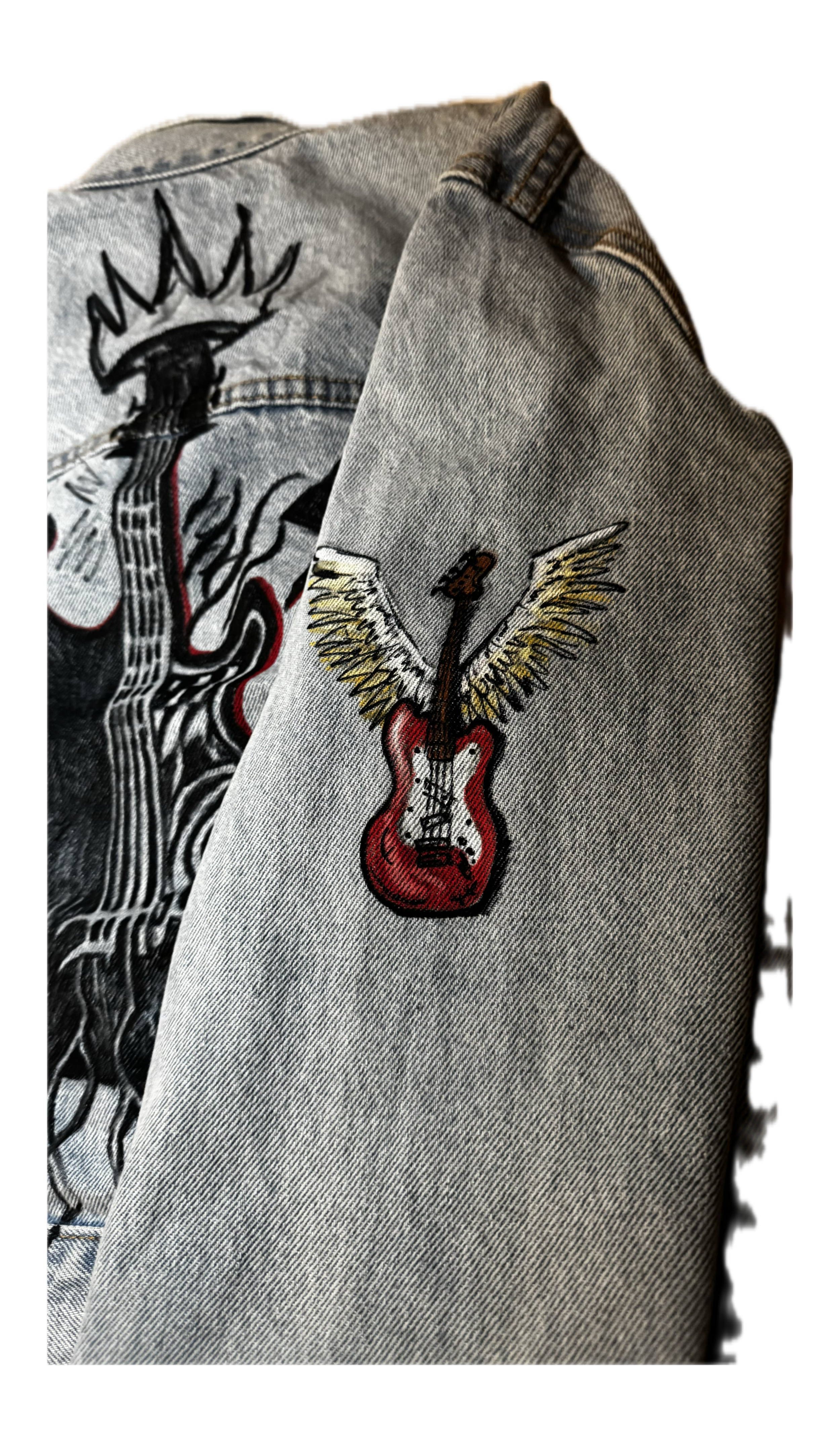 A denim jacket with embroidered patches, including a lightning bolt, a guitar with wings, and a face with long hair.