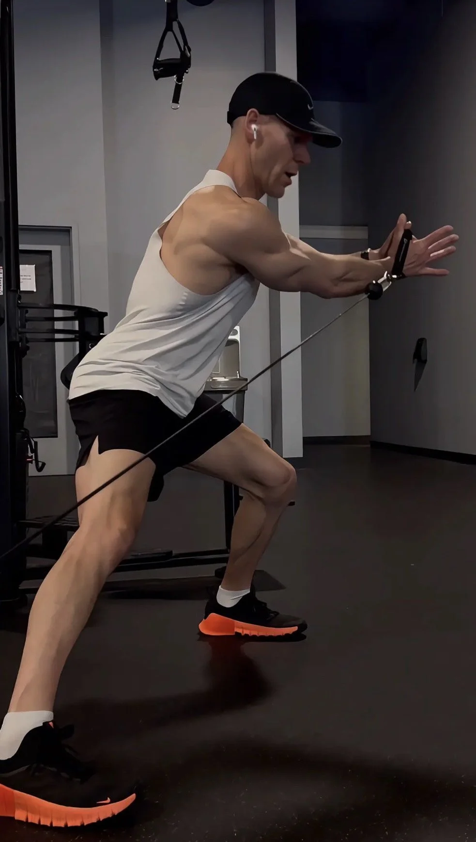 Split-stance cable press used in performance-based strength training to improve stability and full-body strength.
