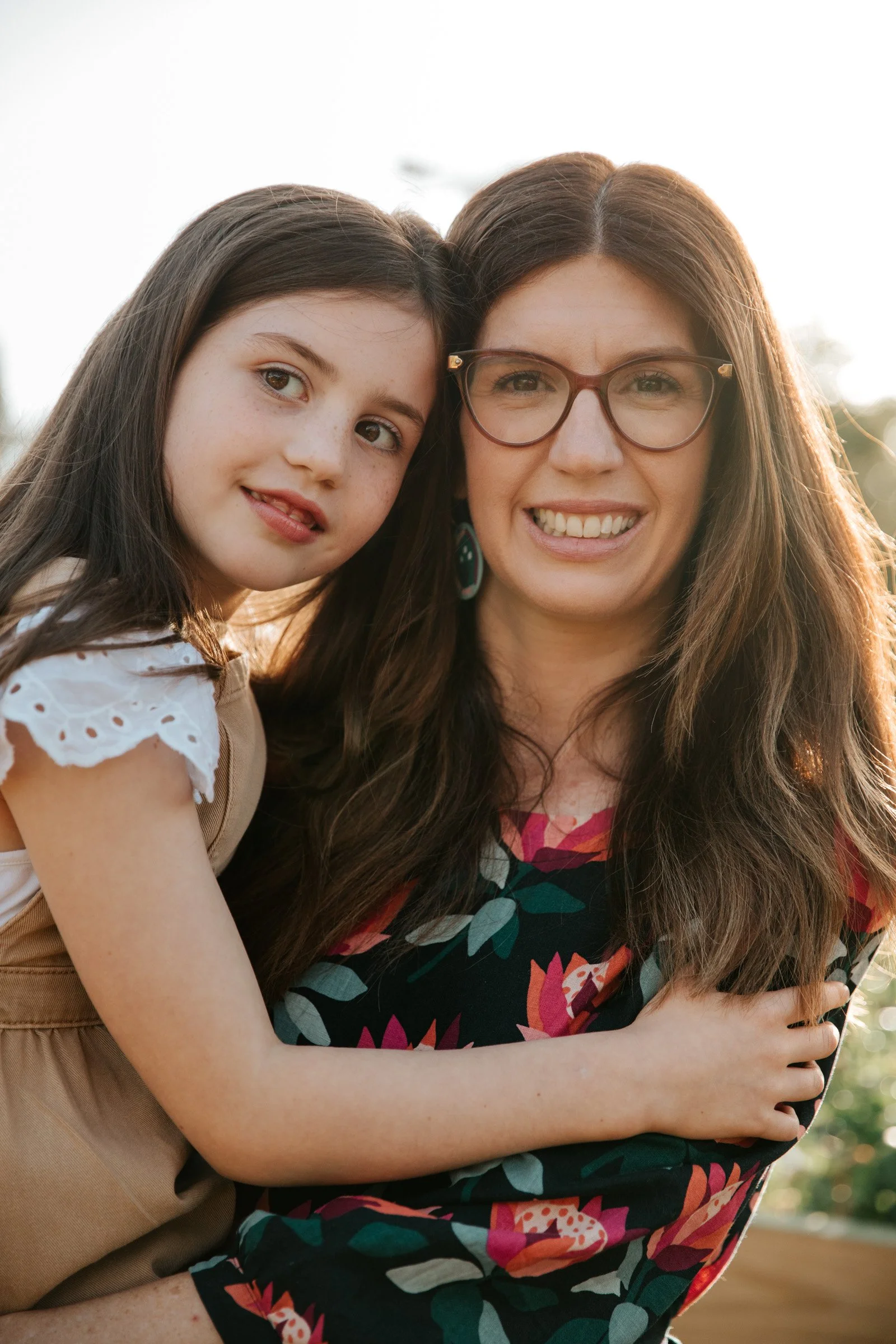Mother and daughter smiling together during an outdoor family photography session