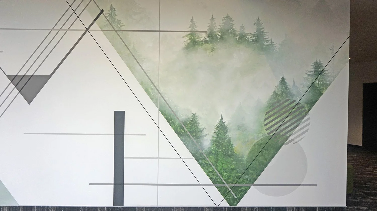 Decorative wall with geometric shapes and a forest scene, featuring trees and fog, along with design lines and patterns.
