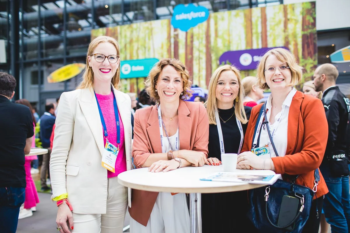 Vier Frauen beim Netzwerken an einem runden Stehtisch auf einer Konferenz, im Hintergrund ein Banner mit Waldmotiv.