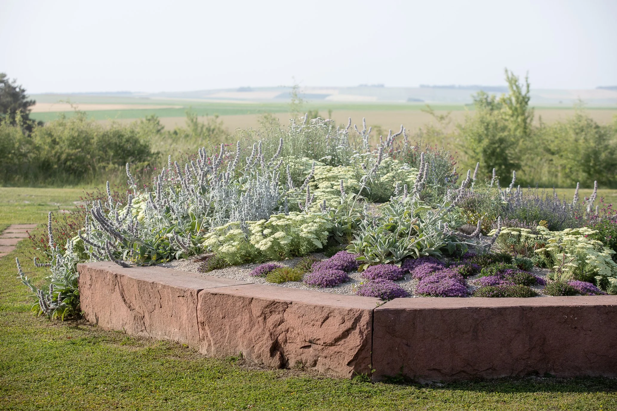 Natural stone edging and climate-adapted planting designed by a landscape architect in Paris