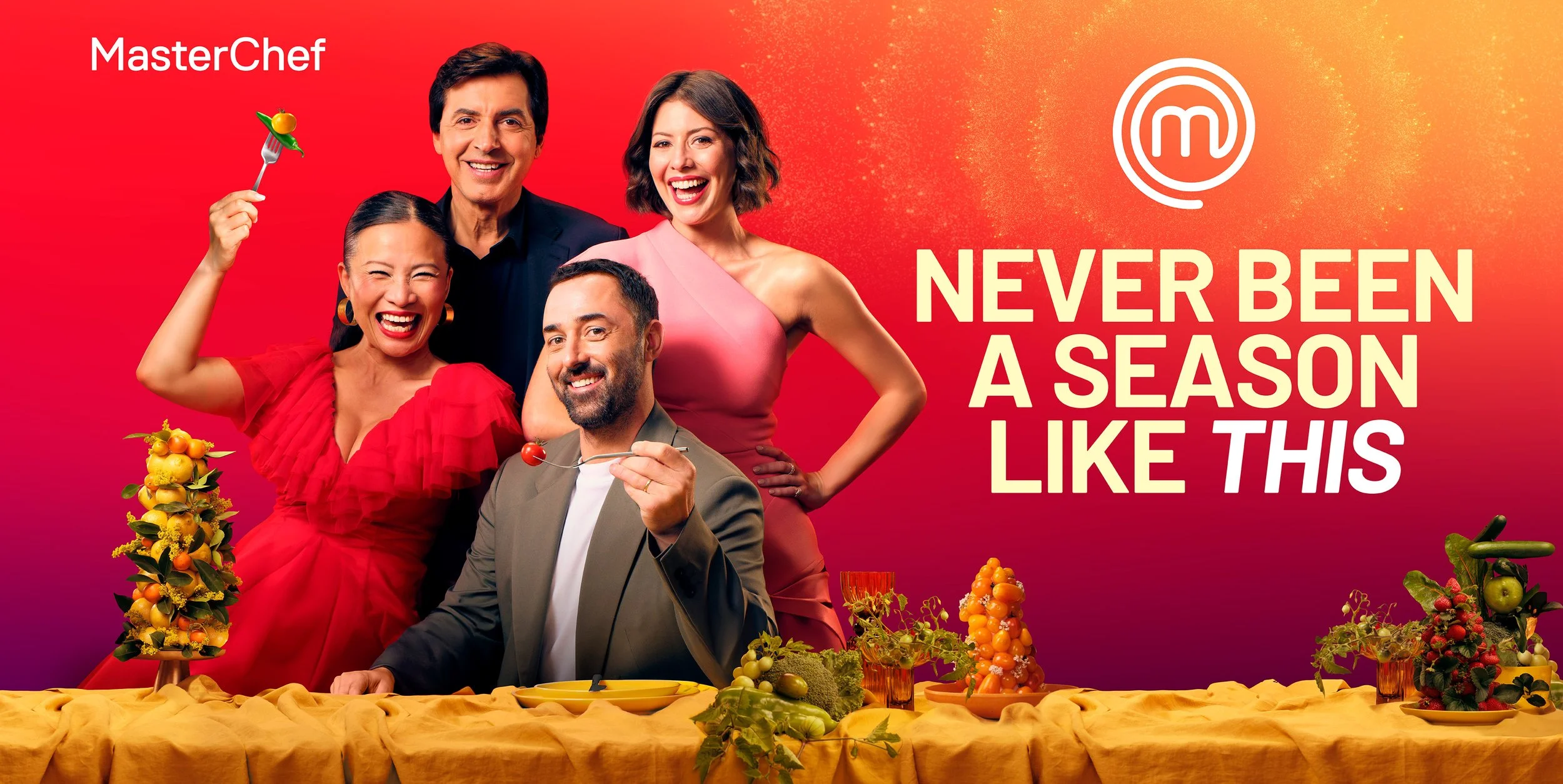 Group of five people, four women and one man, posing with food and colorful decorations against a red and orange background with text that says 'Never Been a Season Like This' and the MasterChef logo.