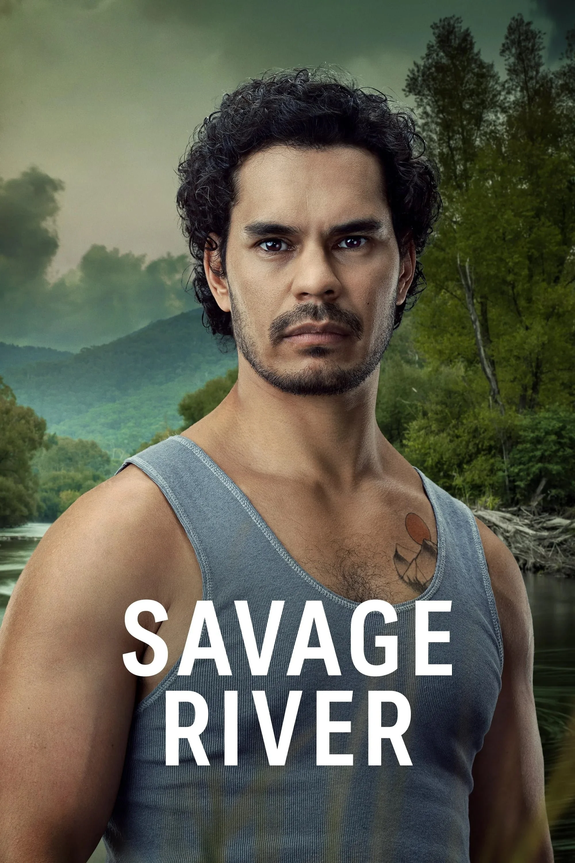 A serious-looking man with dark curly hair, a mustache, and a beard wearing a gray sleeveless shirt, standing in front of a green, forested river landscape with mountains in the background. The words 'SAVAGE RIVER' are written in bold white letters a