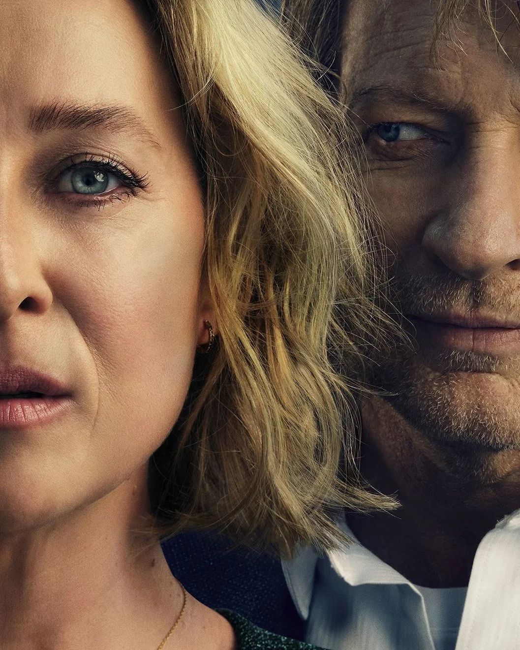 Close-up of a woman with blonde hair and blue eyes and a man with darker skin, blue eyes, and facial hair, showing only half of their faces.