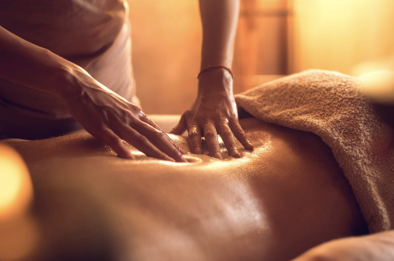 une personne se fait masser le dos  à l'huile dans un cabinet de massage