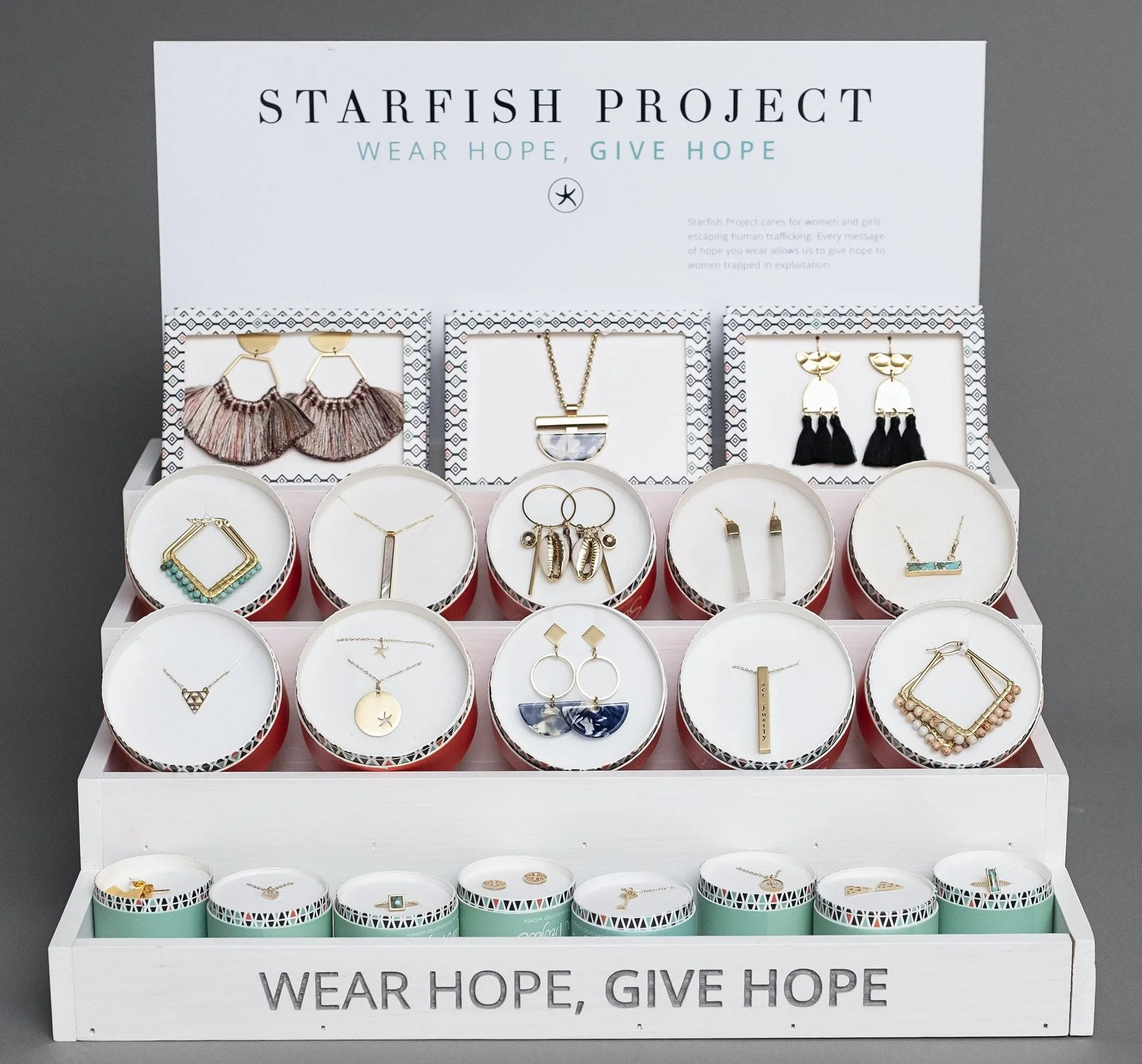 White step display stocked with jewelry and printed header