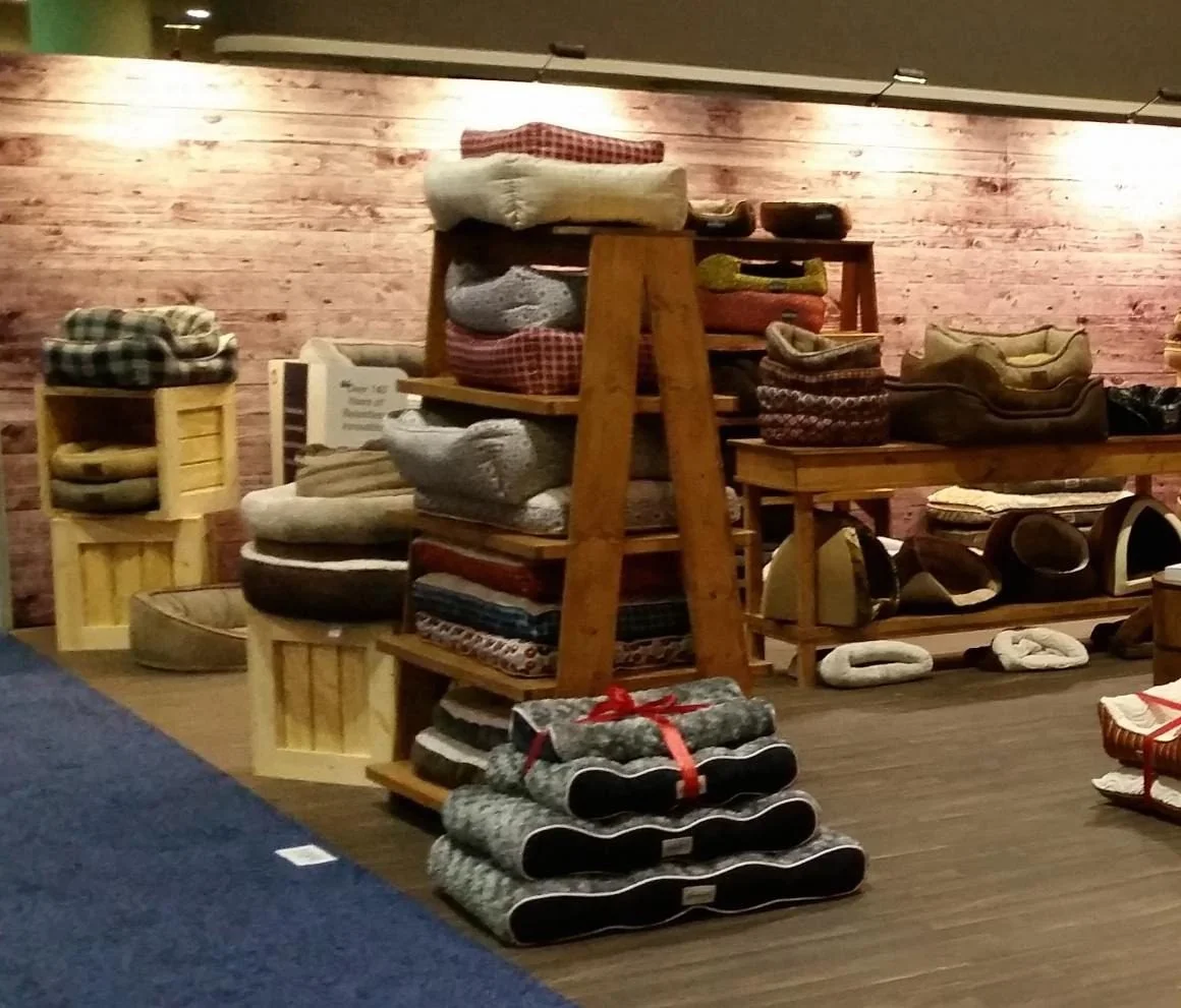 Trade show booth with wood crates and ladder-style display shelves