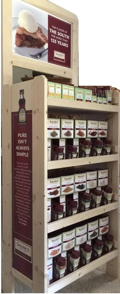 Pine floor merchandiser with slide-in signage stocked with spice extracts