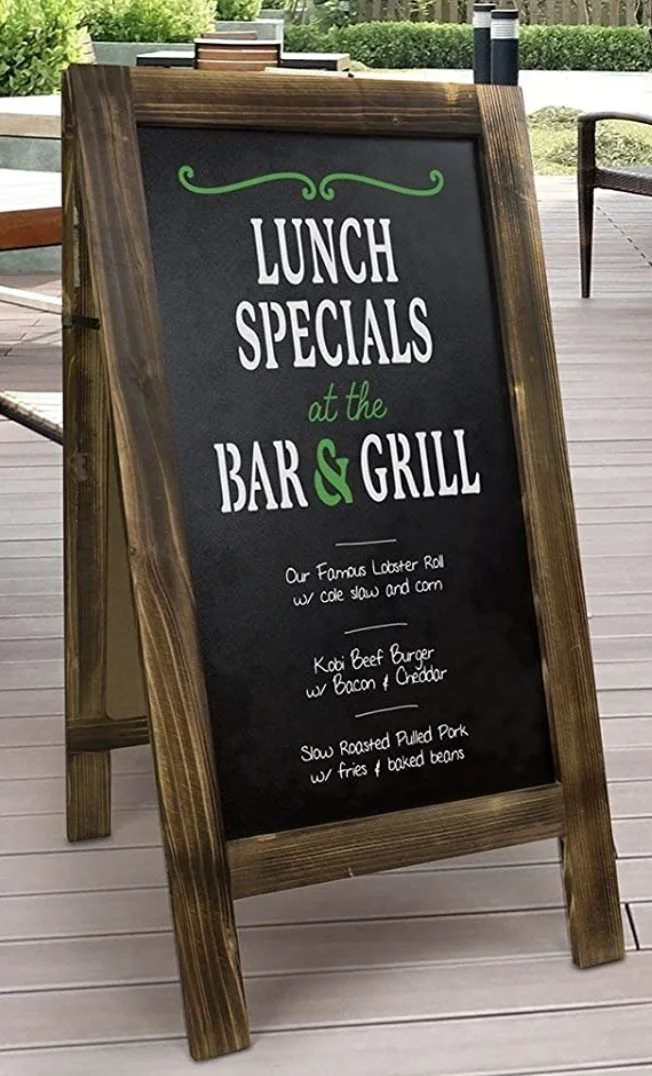 Wood-framed chalkboard sandwich board sign with a restaurant menu