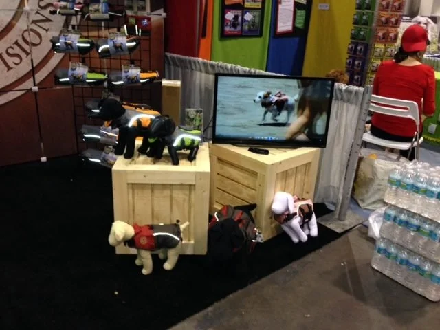 Rustic wood crates used as product risers and a monitor stand in a trade show booth