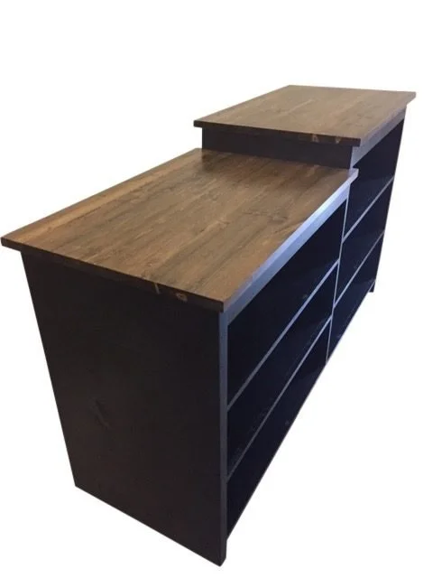 Black stepped sales counter with front shelving