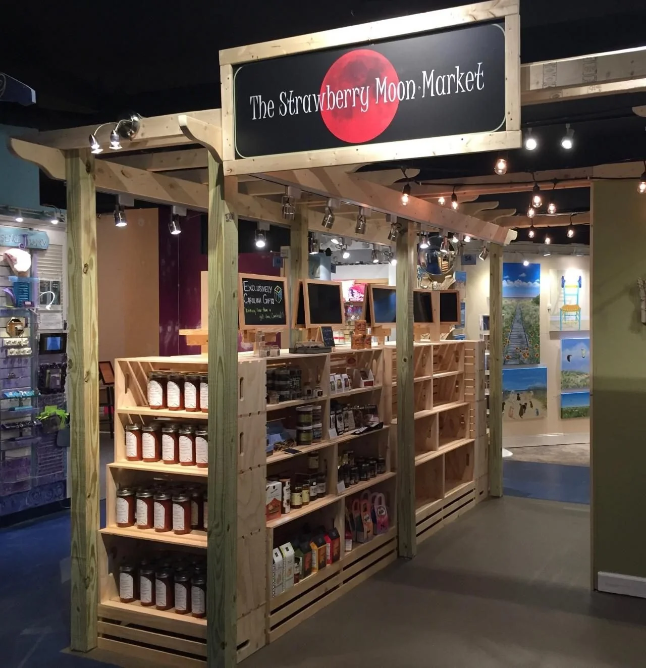 Trade show booth with a wood pergola frame and crate shelving displays