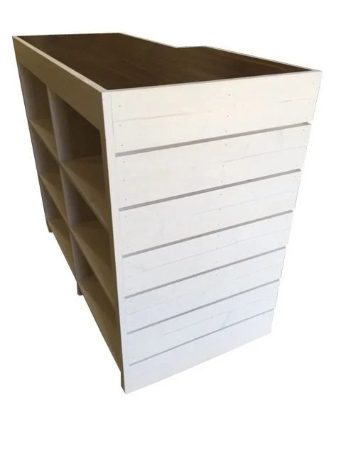 White sales counter with open shelving underneath, rear view