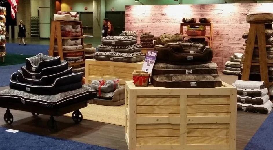 Natural pine display crates and rolling cart at a trade show booth