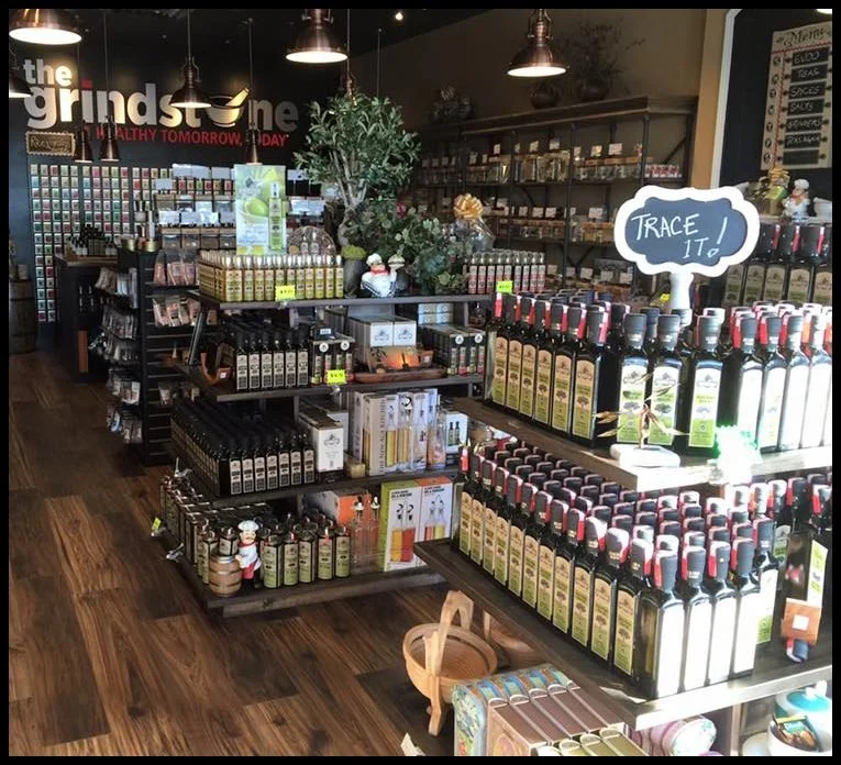 Dark stained island gondolas merchandising olive oils in a gourmet shop