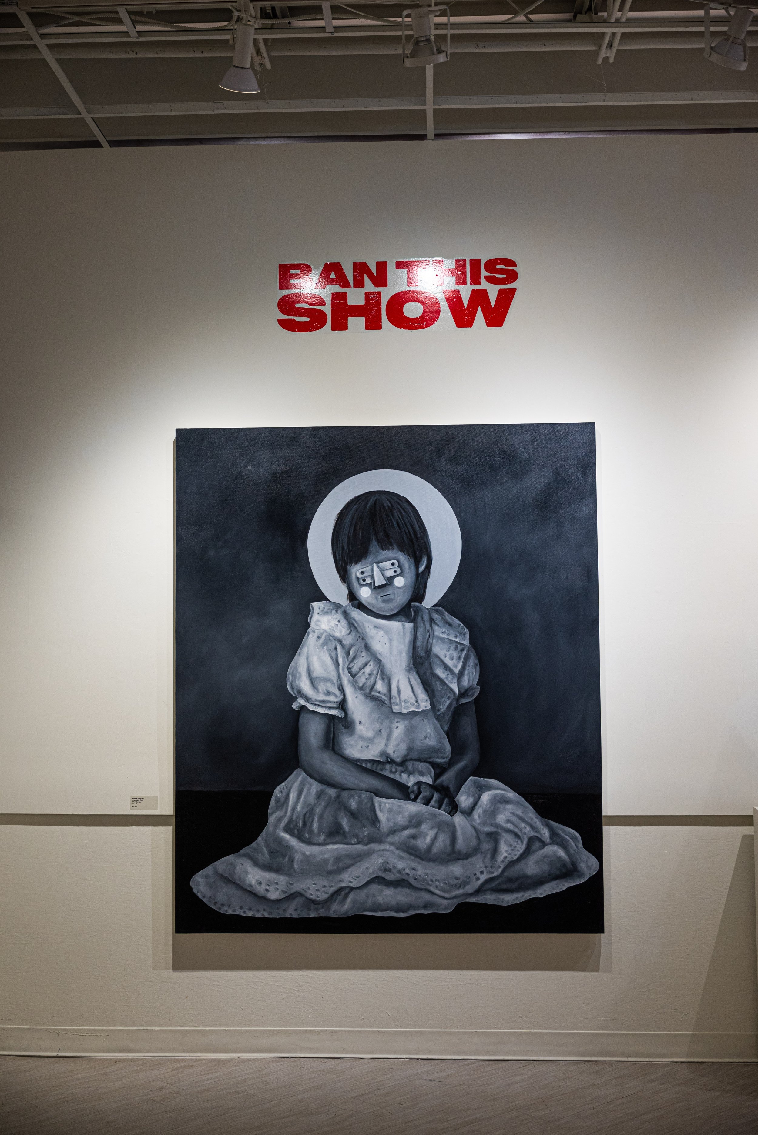 A black and white painting of a young girl sitting on the ground, wearing a dress with puffed sleeves. Behind her is a halo-like circle, and she has a device over her eyes. Above the painting, in red text, it says 'BANT THIS SHOW'.