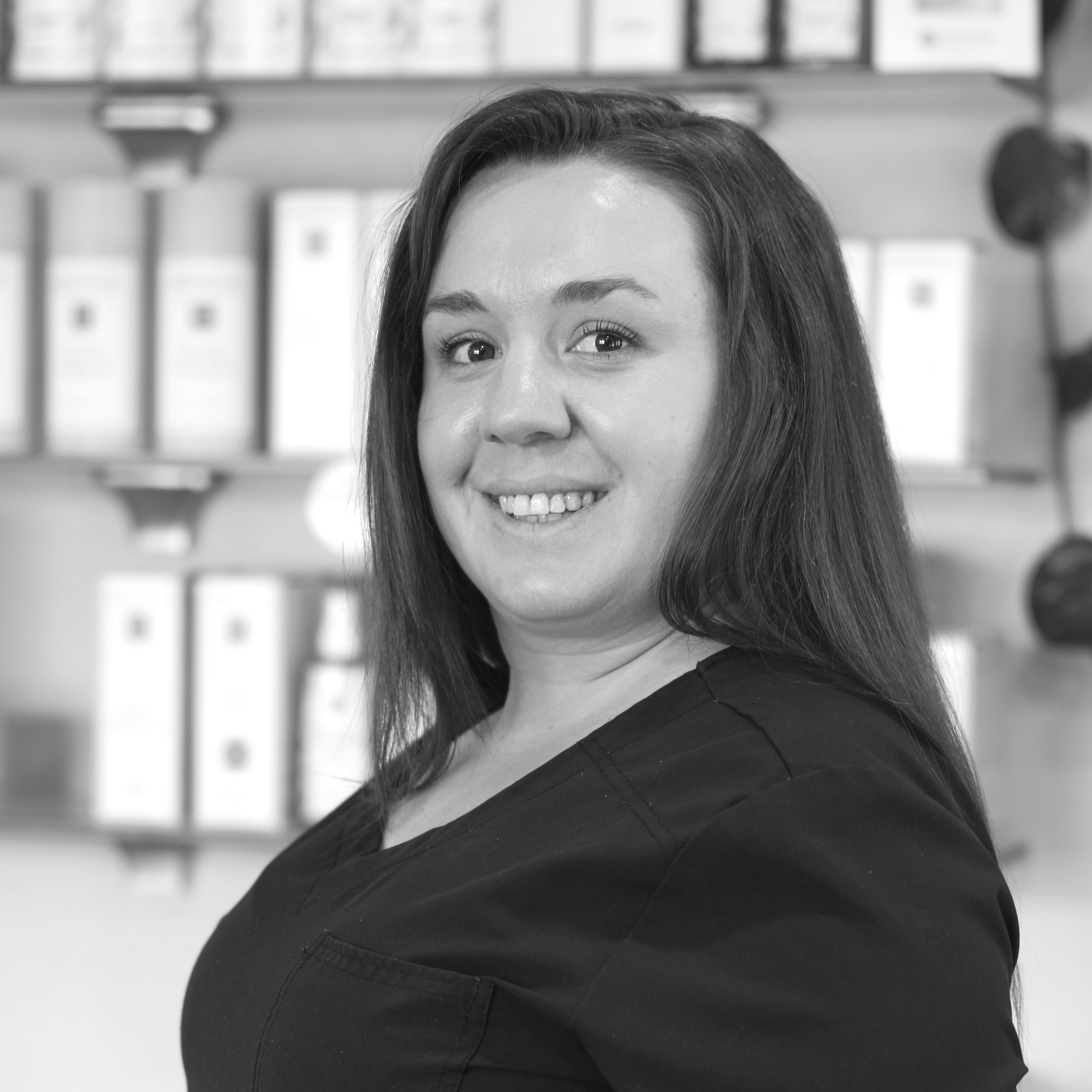 a black and white photo of a woman smiling over her shoulder