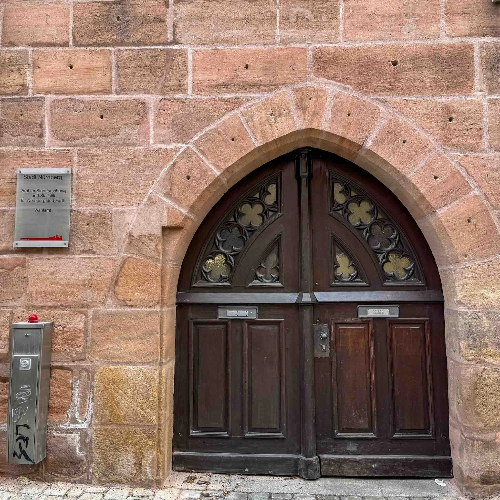 Historische Sandsteinfassade mit dem Schild des Nürnberger Wahlamts. Hier werden die Stimmen der Kommunalwahl verwaltet