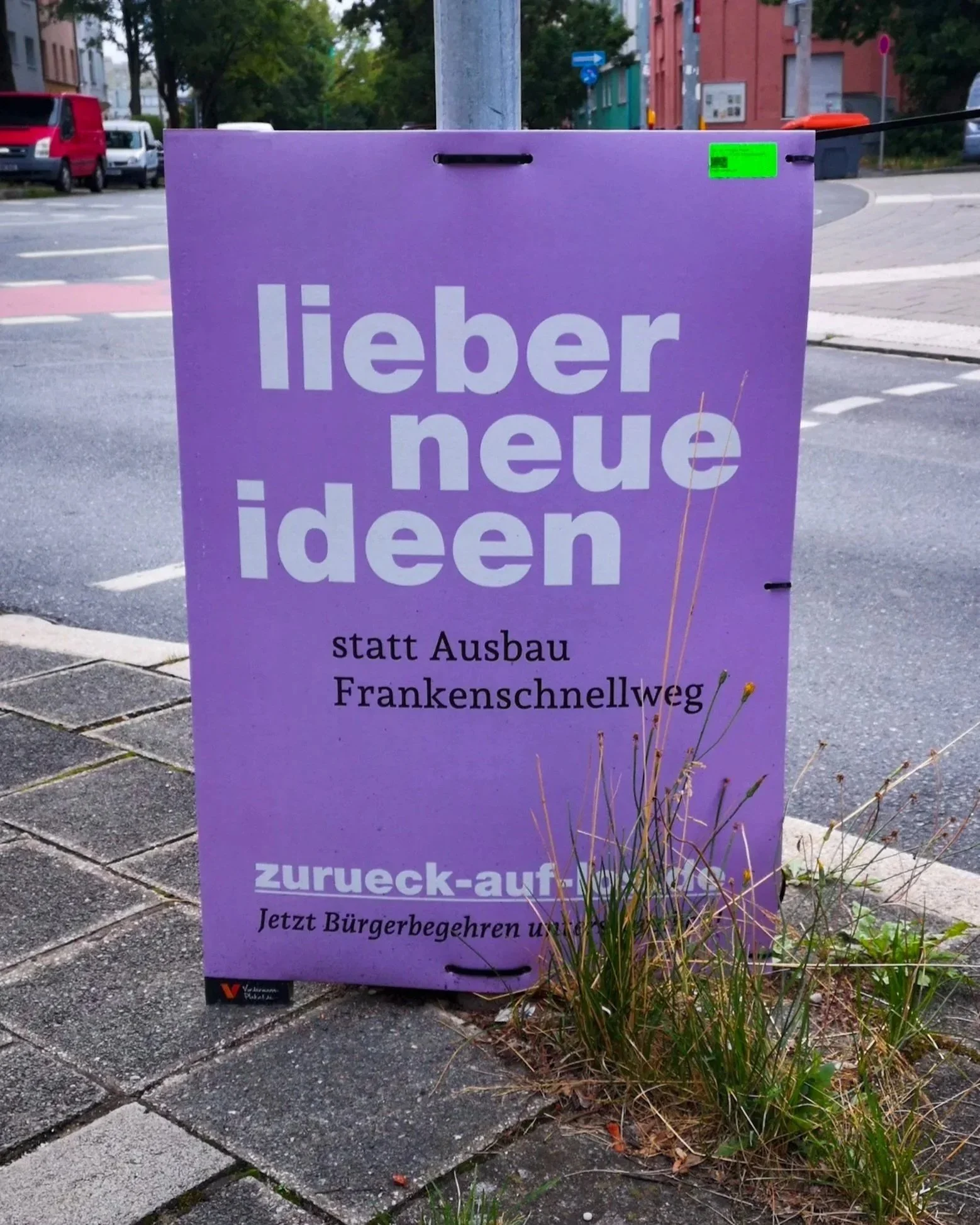  Zwei Wahlplakate auf Nürnberger Straßen zum Bürgerbegehren Frankenschnellweg. Linkes Plakat in Lila: 'lieber neue ideen statt Ausbau Frankenschnellweg' mit Website ' zurueck-auf-los.de '. Rechtes Plakat der Partei Die Linke in Rot: 'Bus und Bahn stä