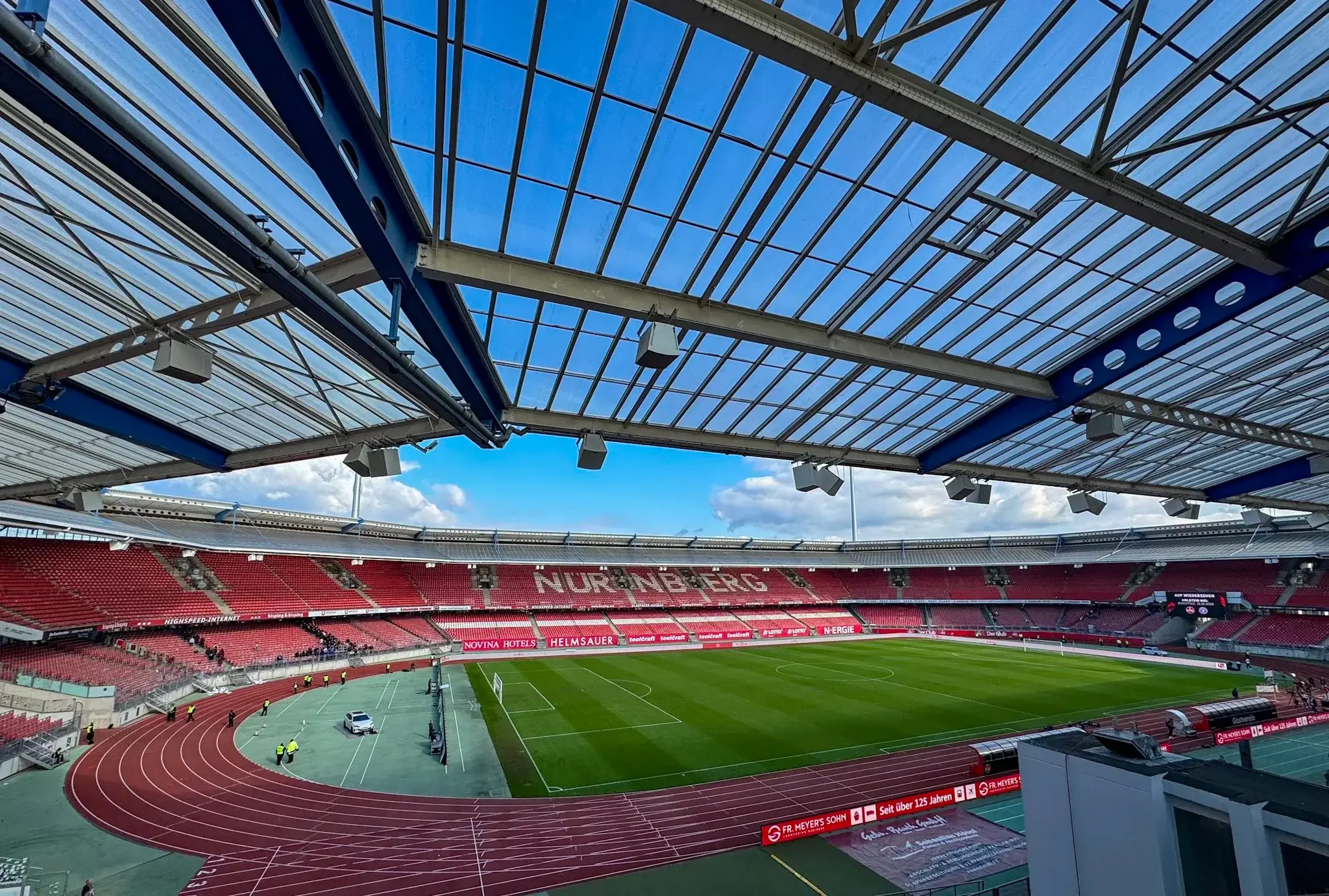 Innenansicht des Max-Morlock-Stadions in Nürnberg mit Blick auf das Spielfeld und die rote Laufbahn unter der Dachkonstruktion