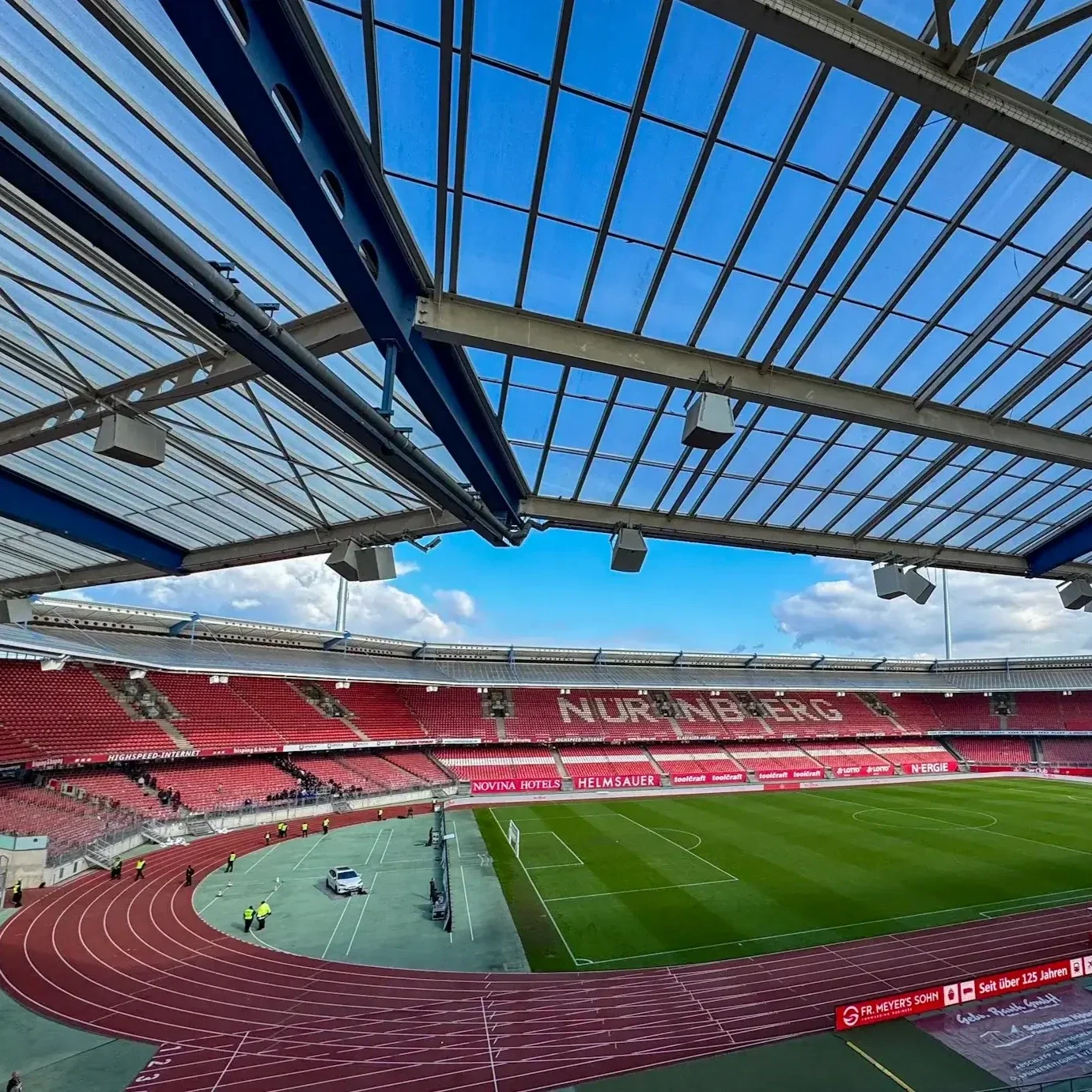 Innenraum des Max-Morlock-Stadions: Blick über die rote Laufbahn auf die leeren Ränge und die markante Dachkonstruktion.