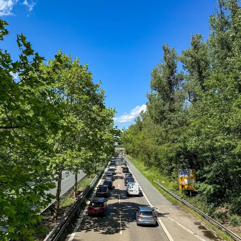 Perspektivische Ansicht von einer Brücke auf den Frankenschnellweg (FSW) in Nürnberg mit dichtem Verkehr und Stau im Streckenabschnitt Sandreuth.