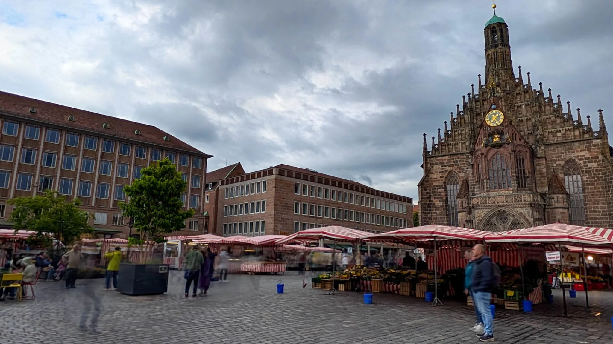 Marktstände mit rot-weiß gestreiften Dächern auf dem Nürnberger Hauptmarkt vor der Frauenkirche.