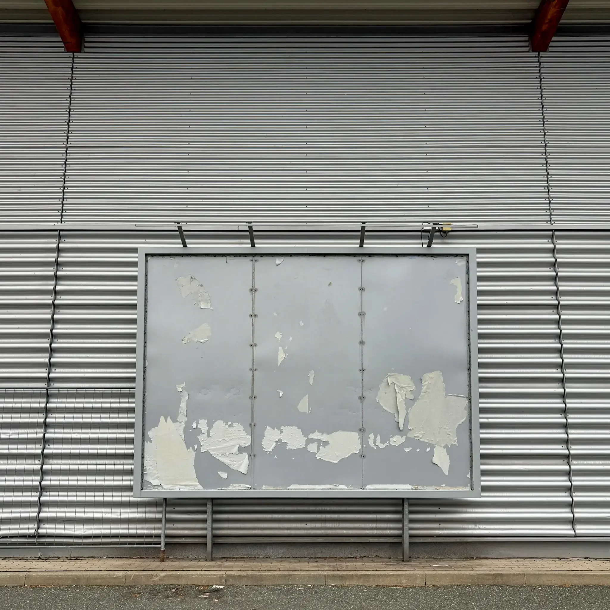 Leere abgenutzte Plakatwand in Nürnberg vor Wellblechfassade – Symbol für den noch nicht gestarteten Kommunalwahlkampf 2026