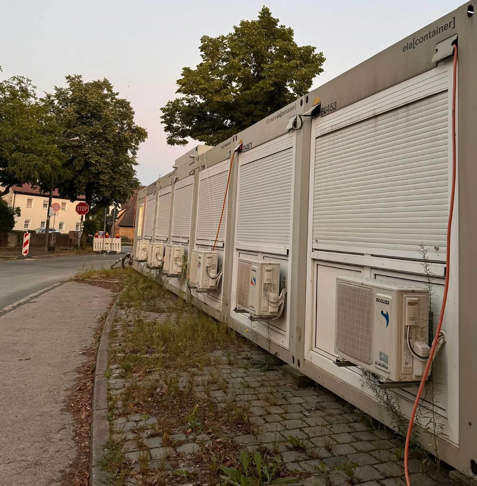 Mehrere Außengeräte von Split-Klimaanlagen sind an einer Reihe weißer Container in Neunhof / Nürnbergmontiert.
