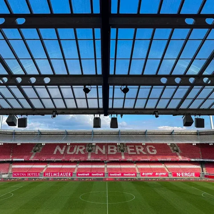 Innenansicht des Max-Morlock-Stadions in Nürnberg: Blick auf die Tribünen mit dem großen Nürnberg-Schriftzug unter der charakteristischen Dachkonstruktion.