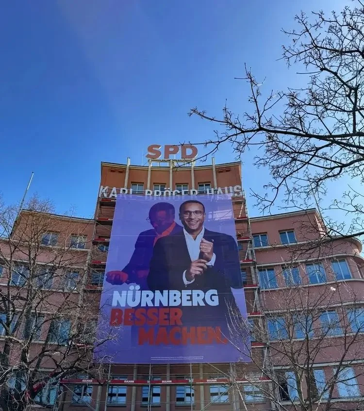 Das Karl-Bröger-Haus in Nürnberg mit einem riesigen Wahlplakat der SPD. Darauf ist Spitzenkandidat Nasser Ahmed mit dem Slogan „Nürnberg besser machen“ zu sehen. Symbolbild für den ambitionierten Wahlkampf der Nürnberger Sozialdemokraten.