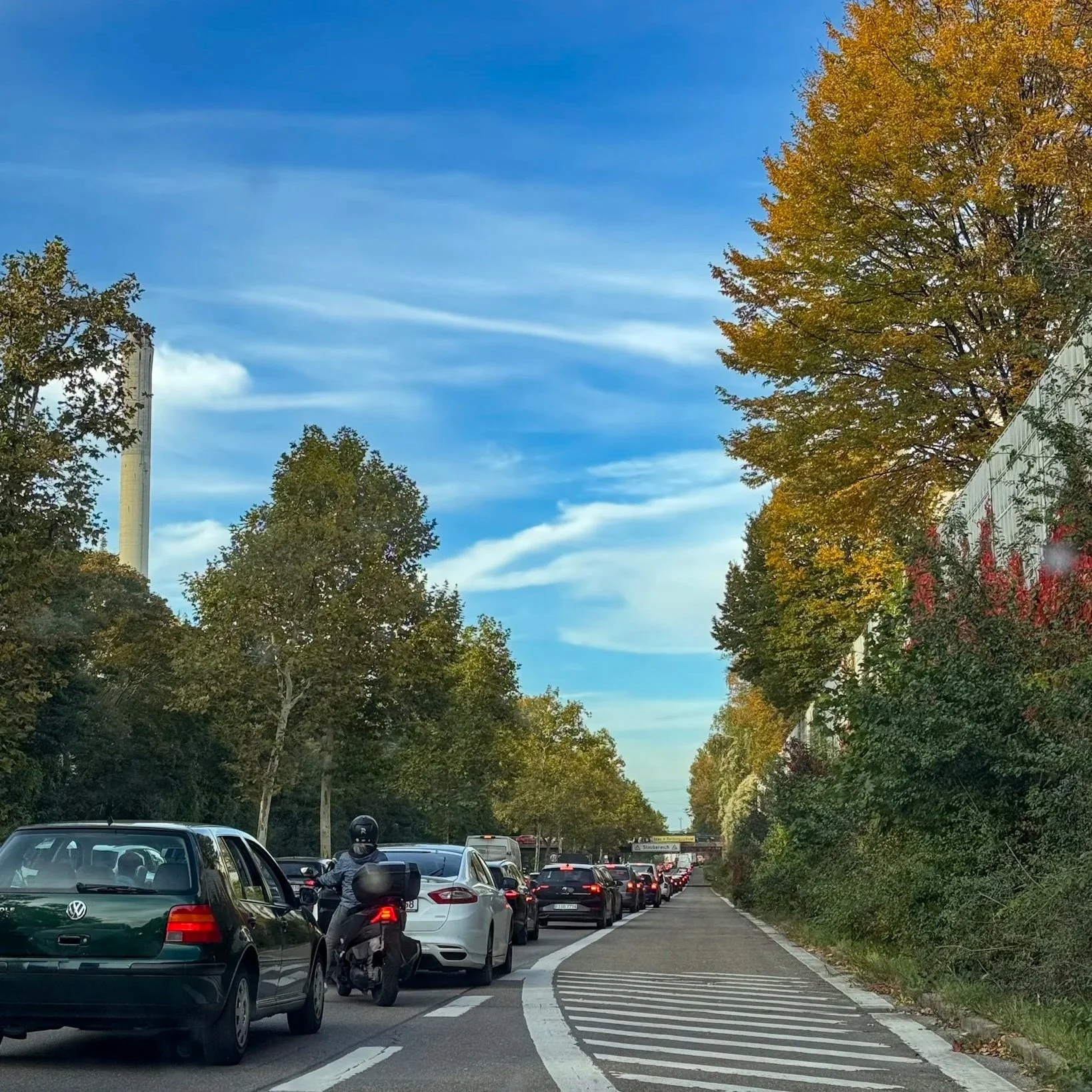 Verkehrsstau auf dem Nürnberger Frankenschnellweg mit herbstlichen Bäumen und blauem Himmel. Foto: © Janine Beck