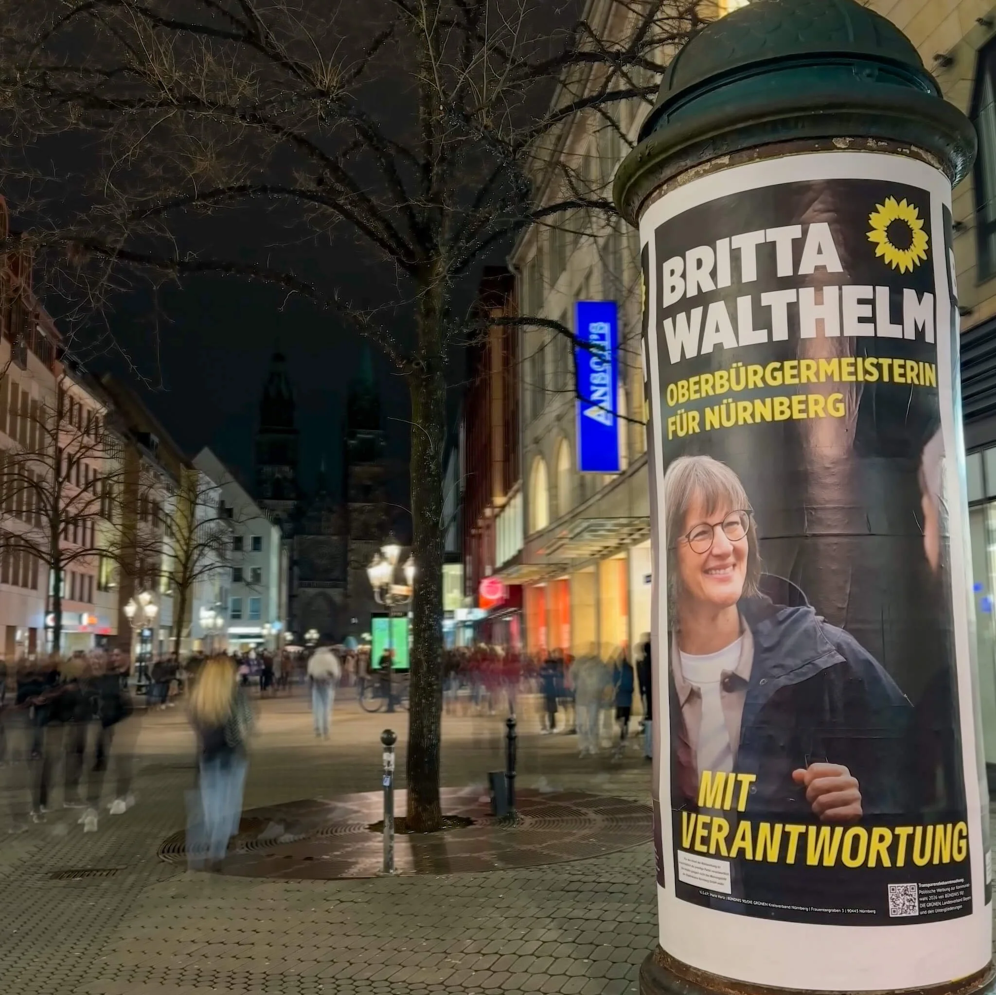 Wahlplakat von Britta Walthelm zur Oberbürgermeisterwahl in der Nürnberger Karolinenstraße bei Nacht.