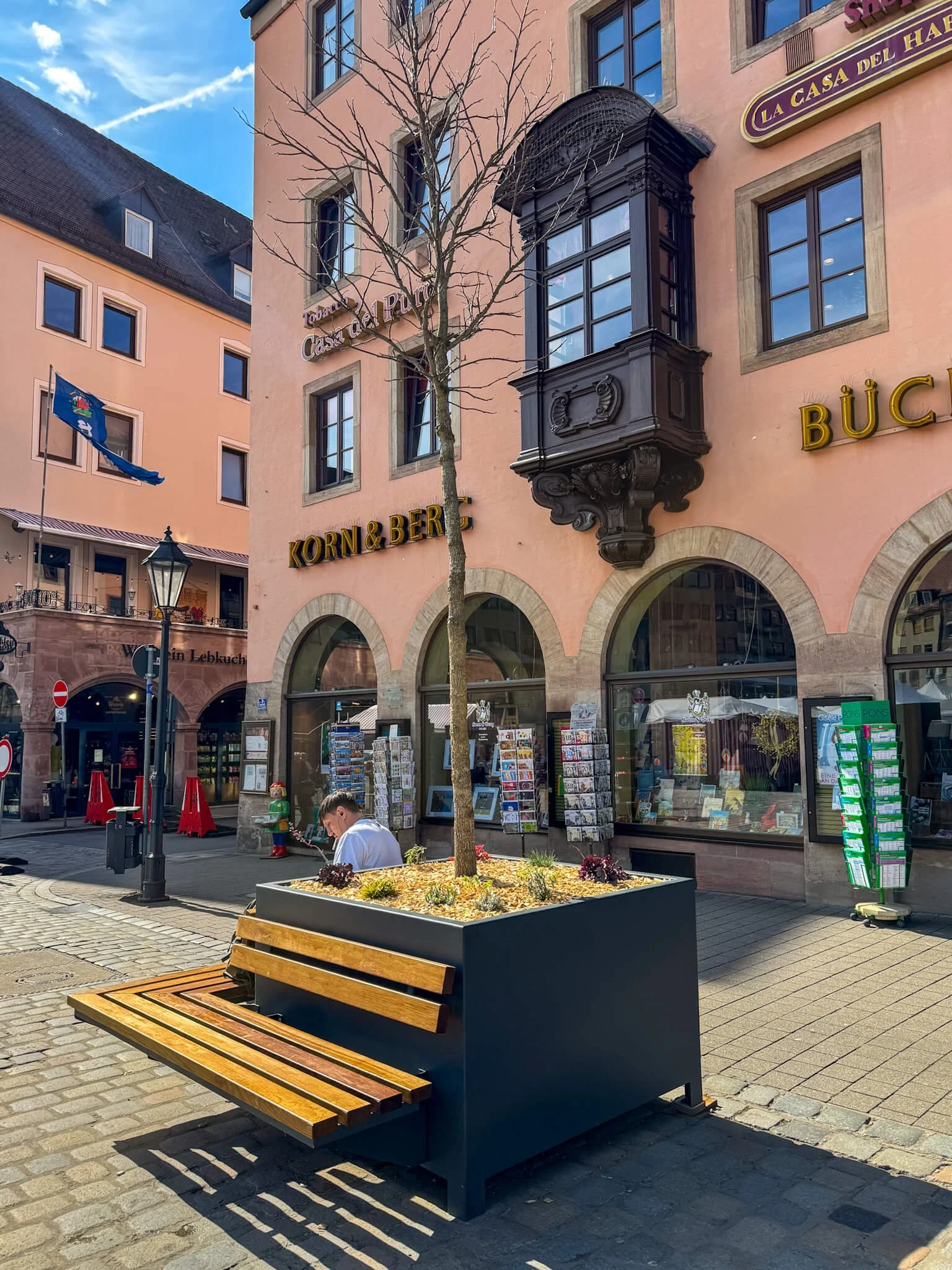 Baumtrog mit Sitzbank auf dem Nürnberger Hauptmarkt vor der ältesten Buchhandlung Deutschlands.