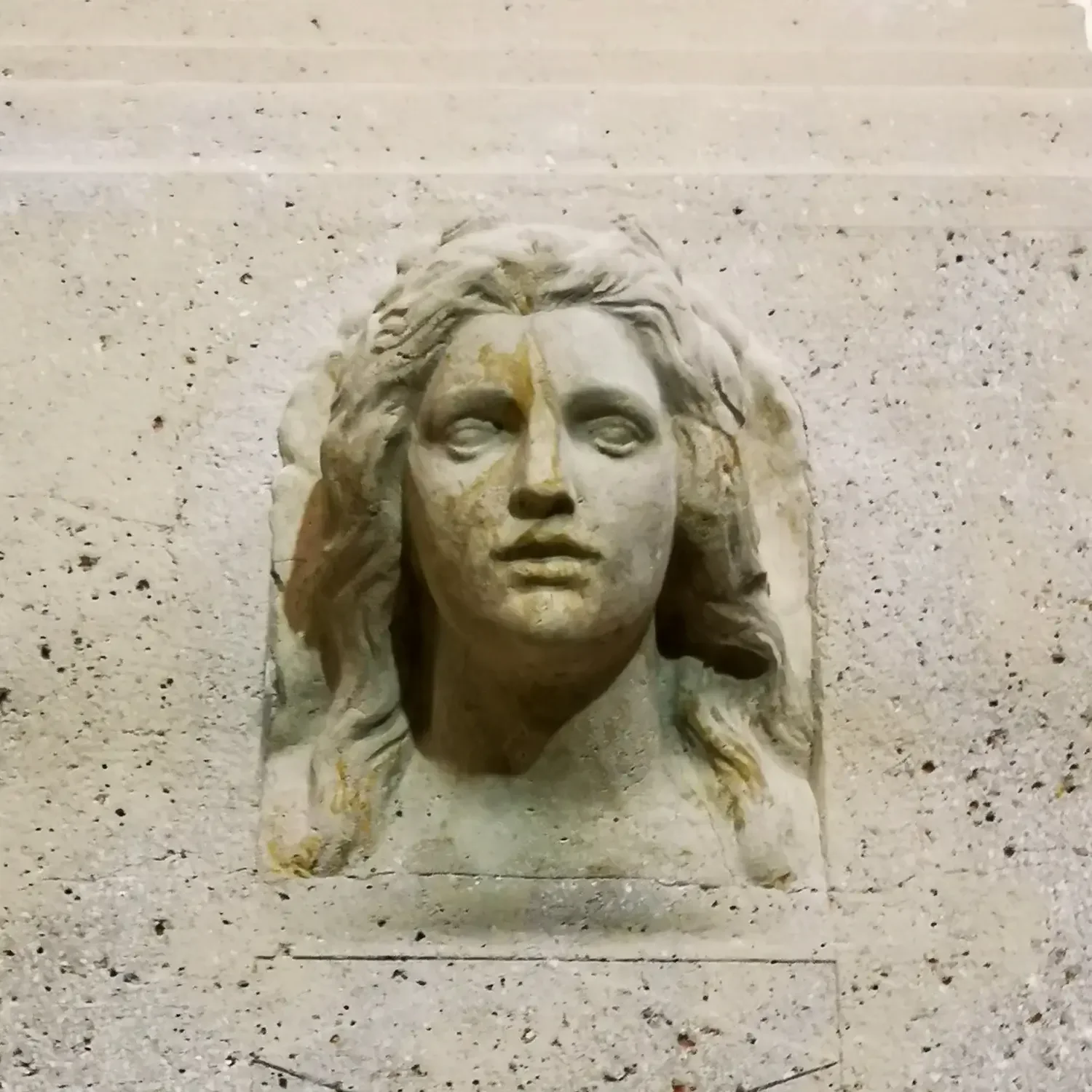 Steinernes Jugendstil-Relief mit Frauenkopf an der Fassade des Volksbads Nürnberg