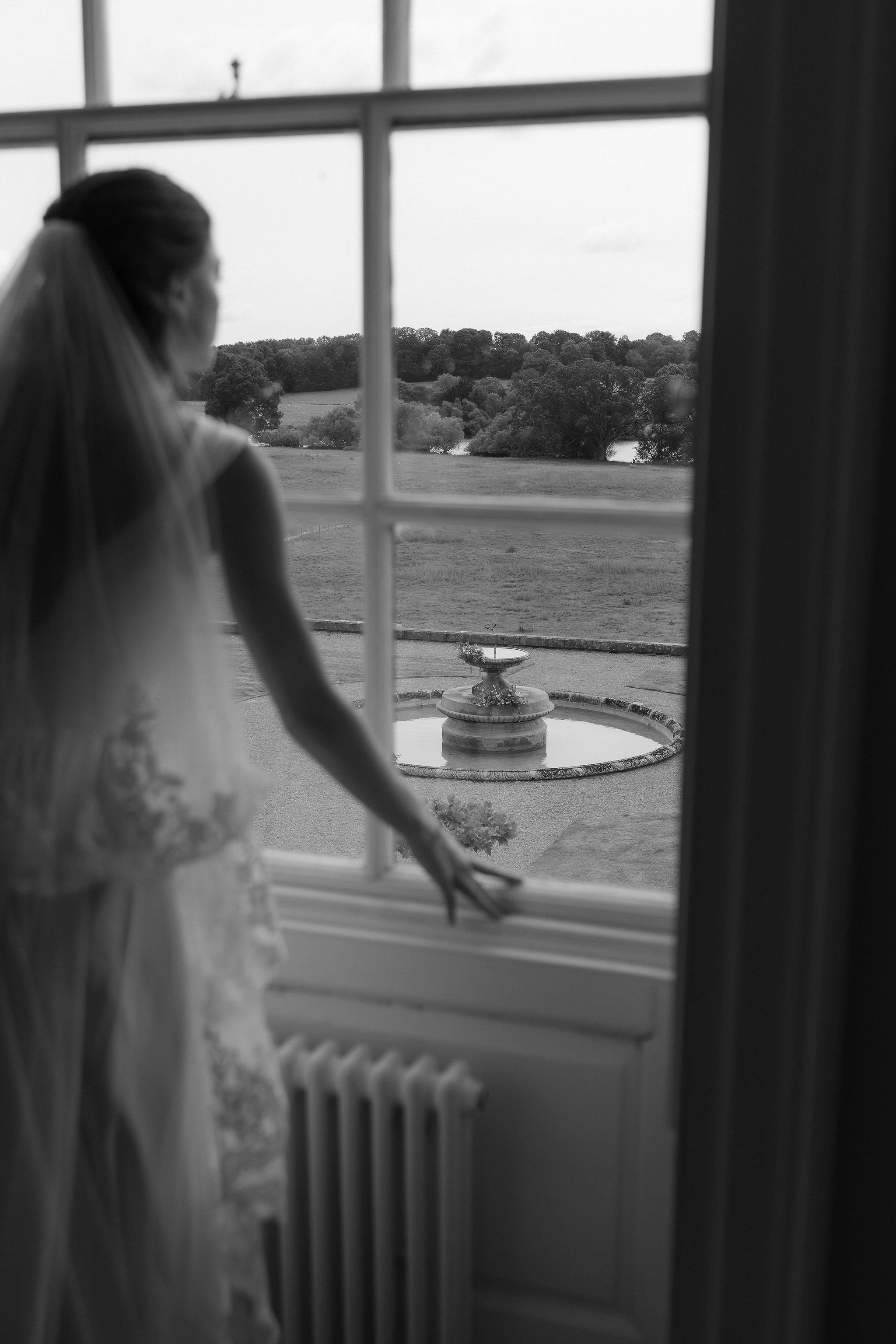Bride looking out at the water fountain ceremony flowers