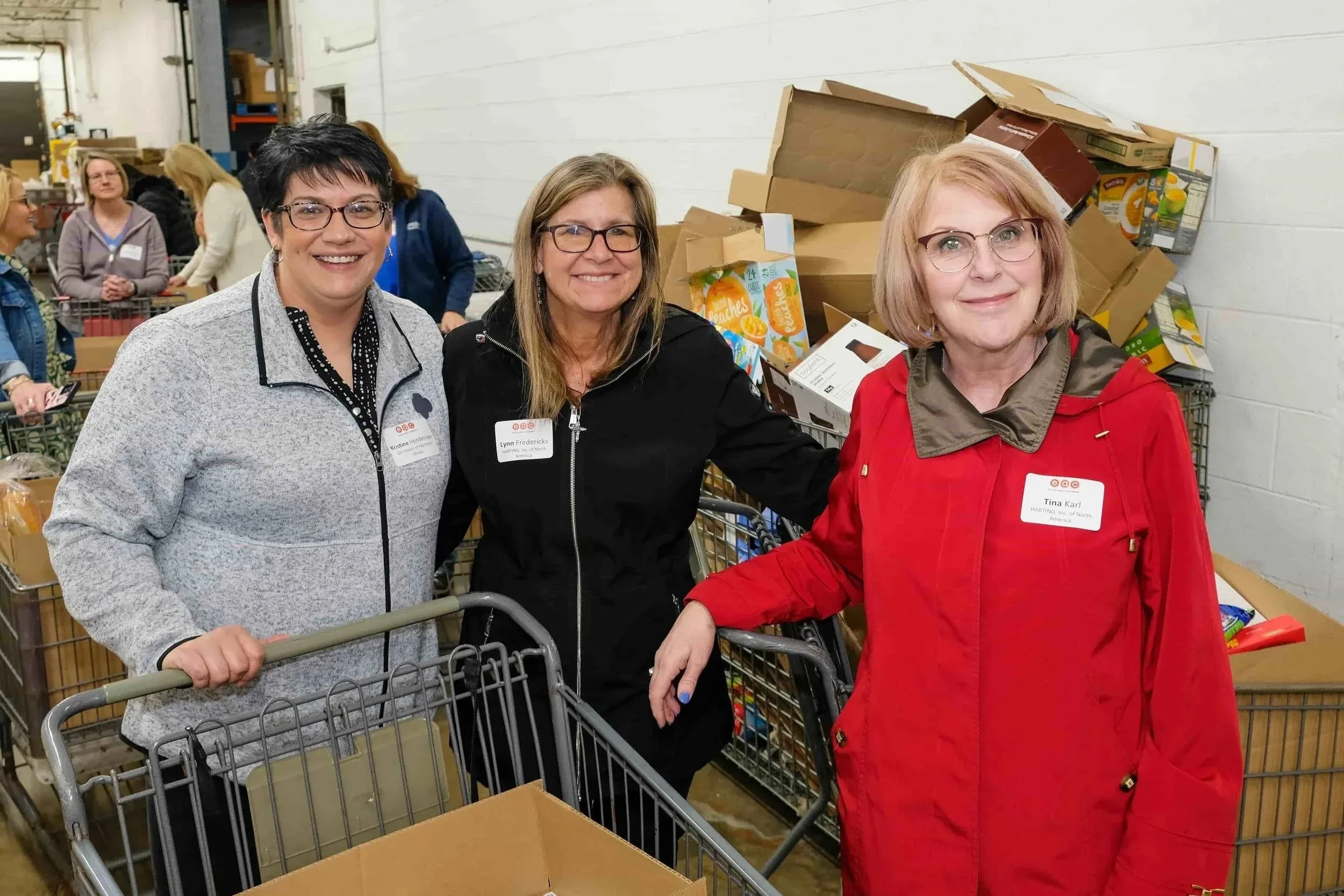 A group of volunteers from Elgin Area Chamber's Women's Leadership Circle pushing a shopping cart at Food for Greater Elgin's food pantry.
