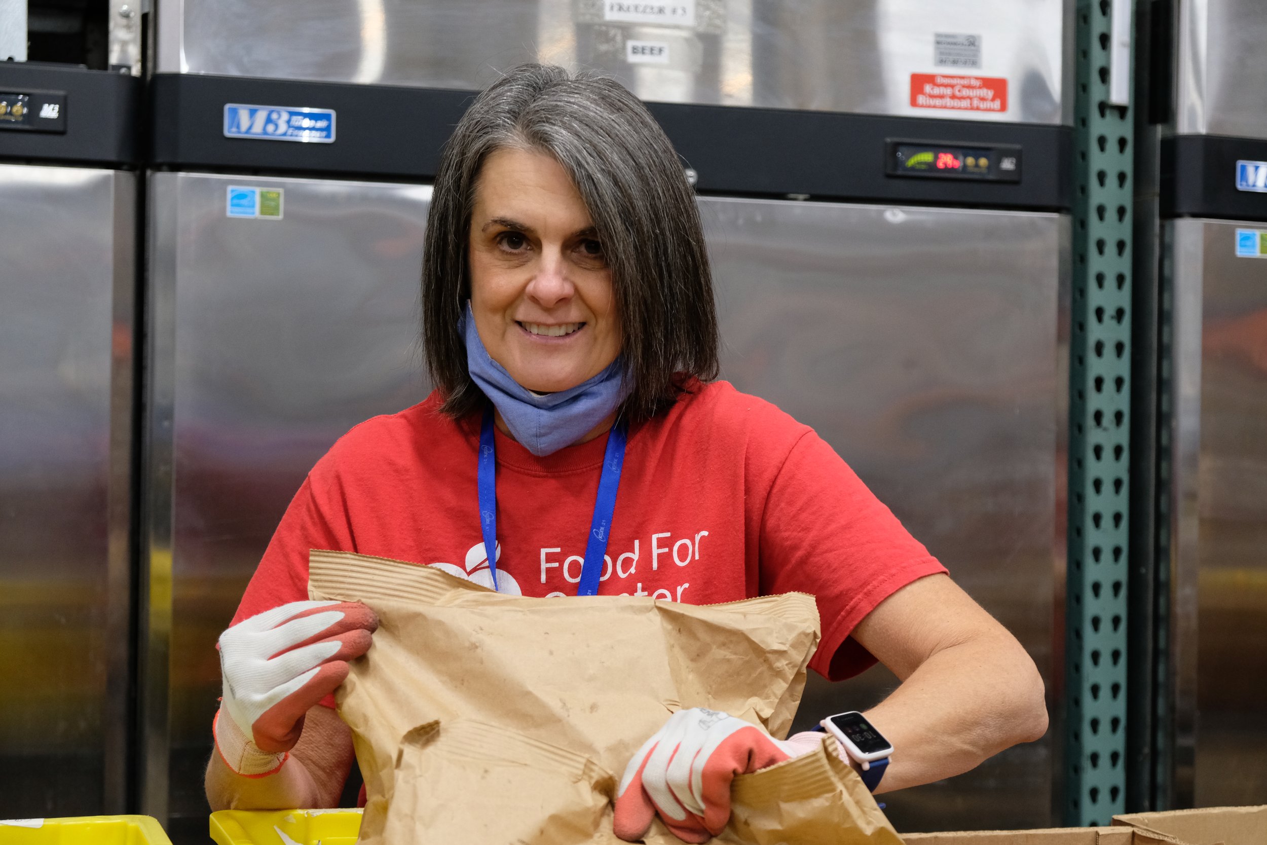 A volunteer sorting through bags of food at Food for Greater Elgin's food pantry.