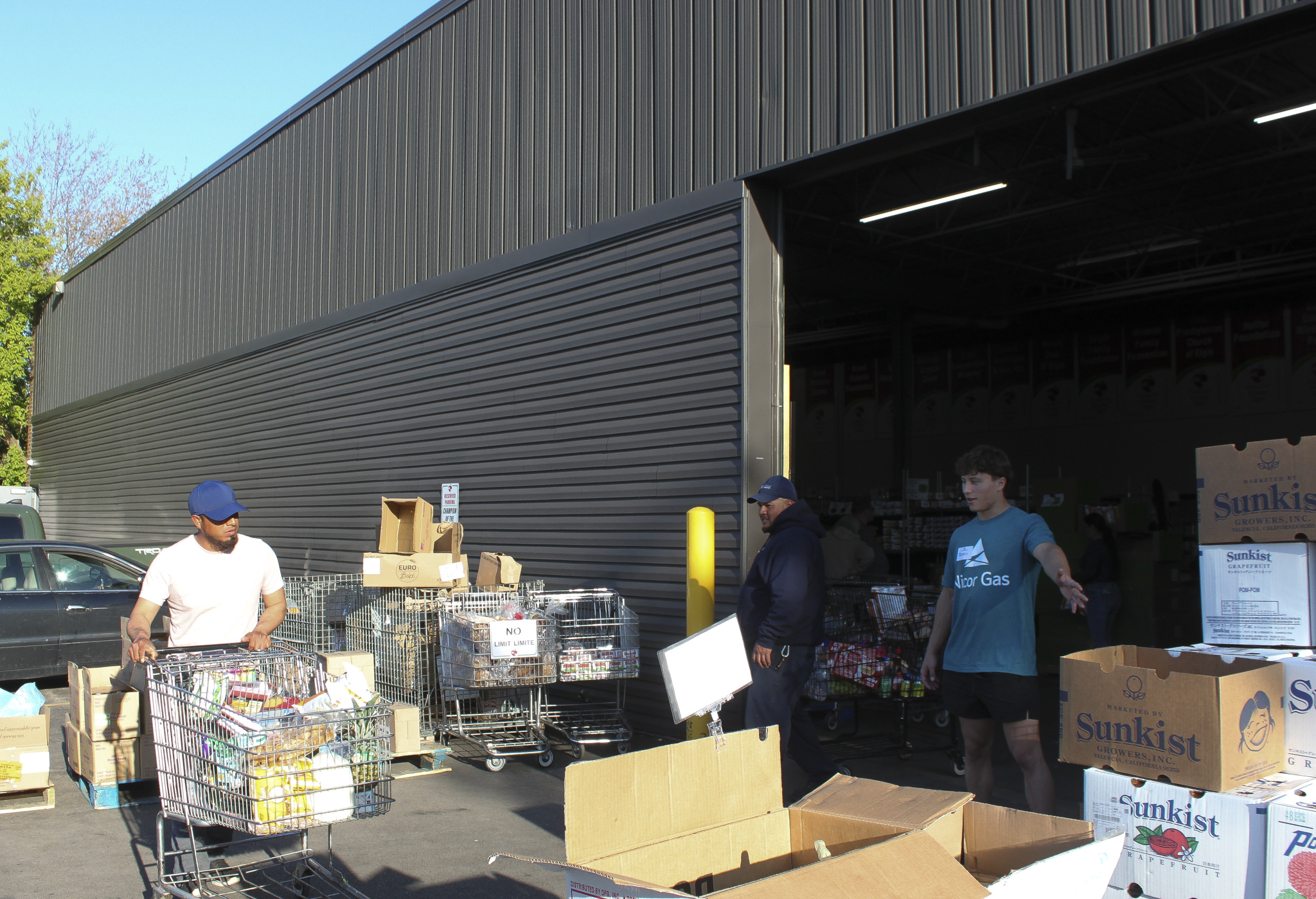 Guests pushing shopping carts full of food while they shop at Food for Greater Elgin's food pantry.