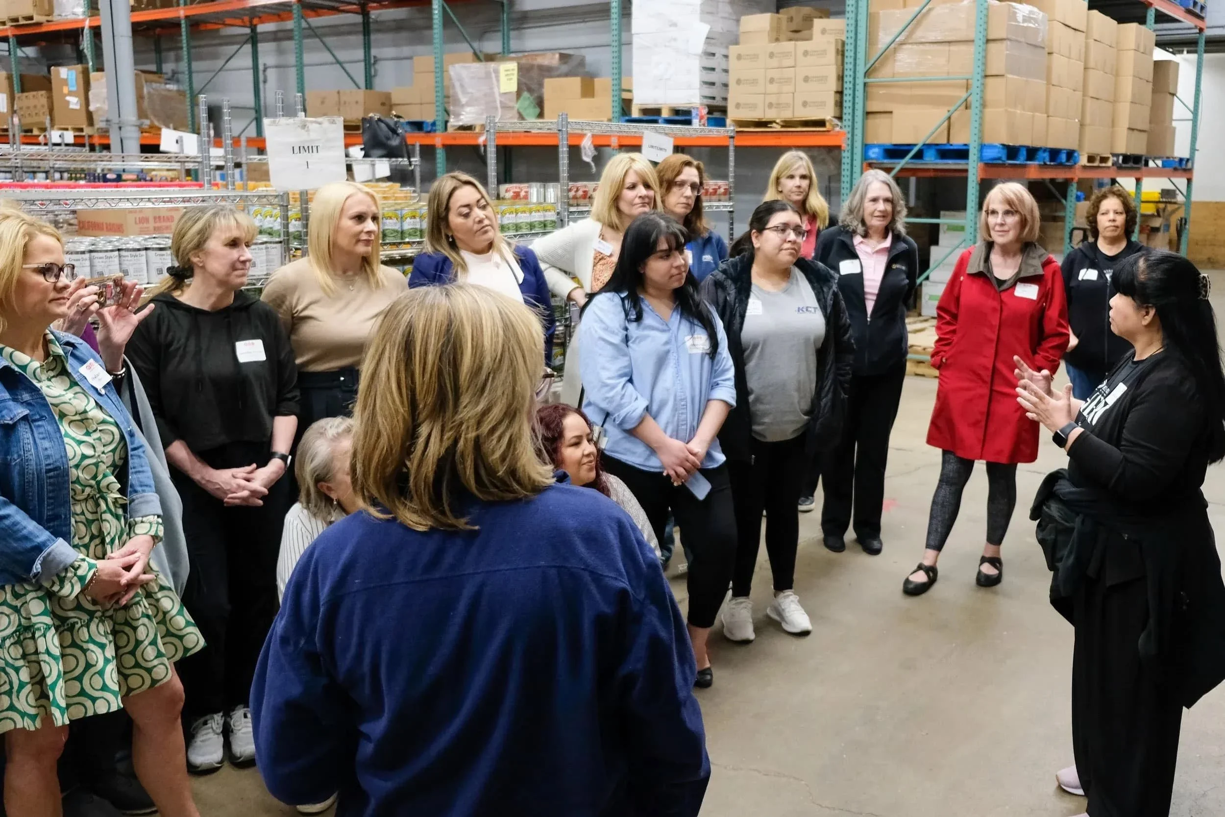 A group of volunteers participating in a warehouse tour at Food for Greater Elgin.