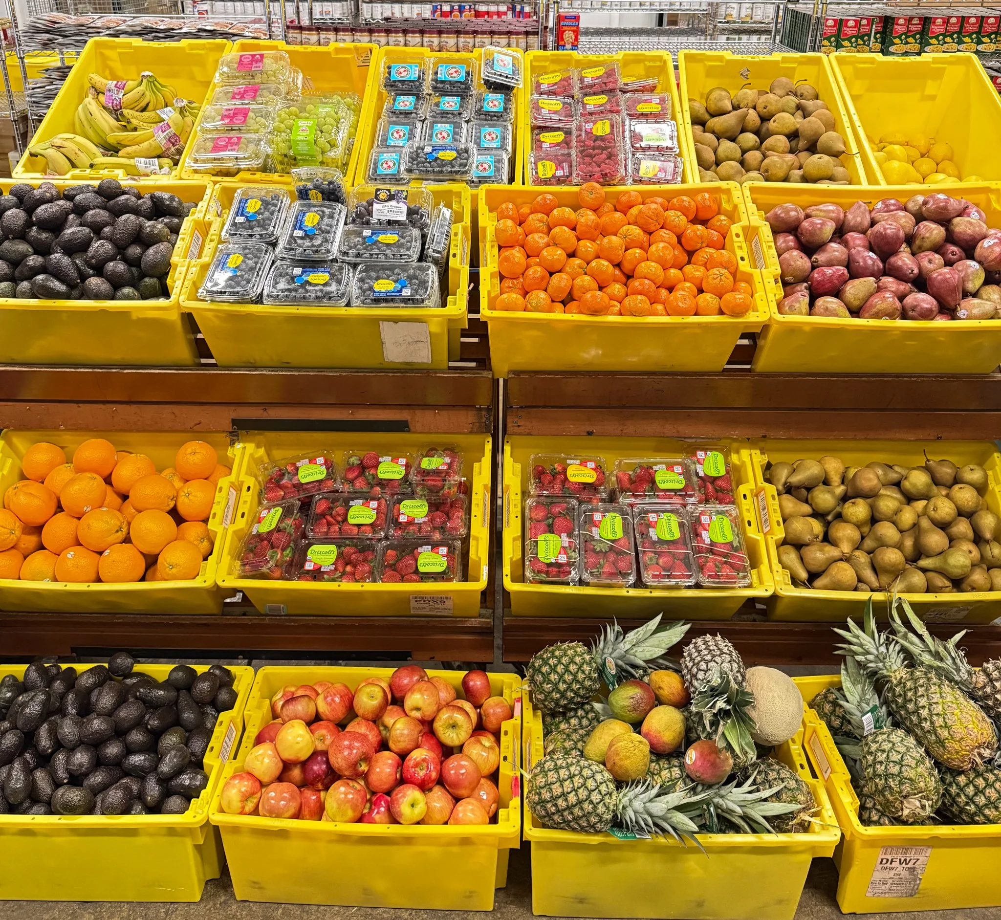 Overflowing bins of fresh fruit on shelves at Food for Greater Elgin's food pantry.