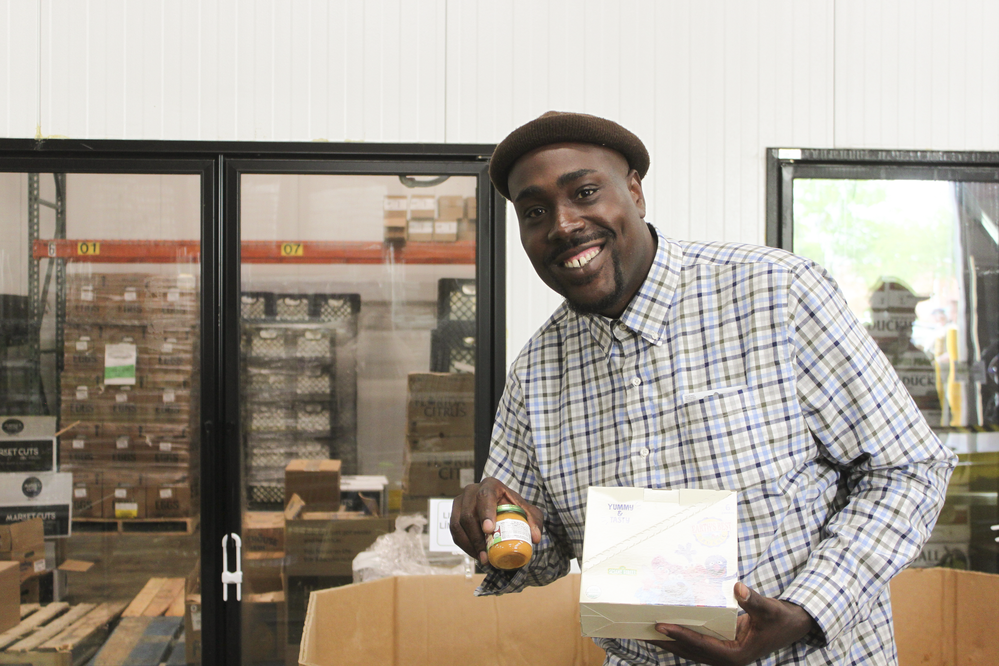 Man smiling and showing off his groceries, excited for the pantry goals for 2027.