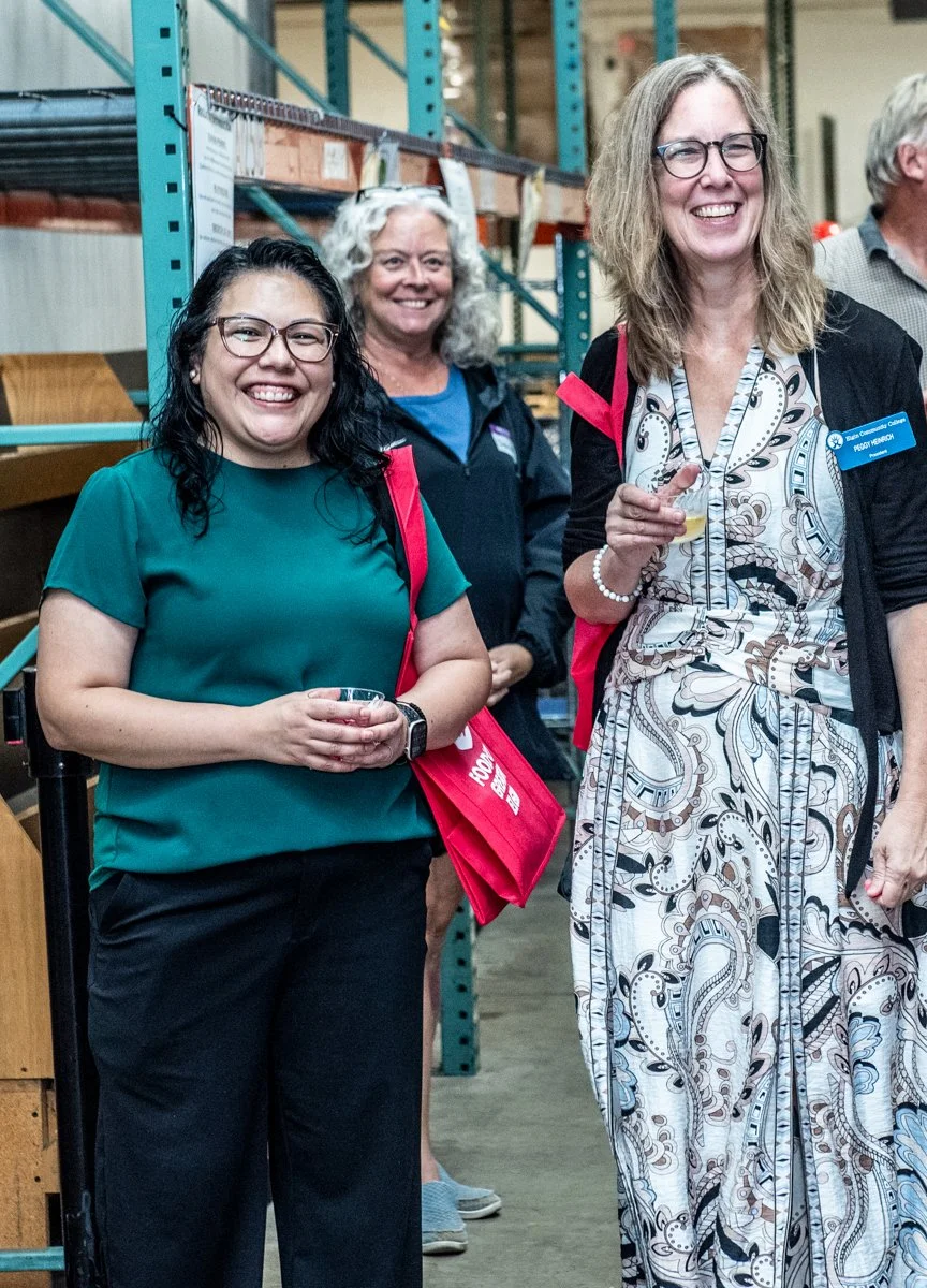 Three women smiling at the Food for Greater Elgin open house.