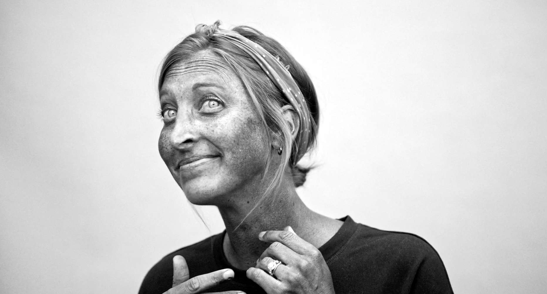 Black and white UV camera footage showing dark, even sunscreen coverage on a woman's face.