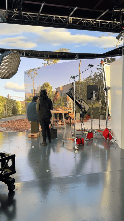 Behind the scenes on set showing a virtual environment alongside production equipment.