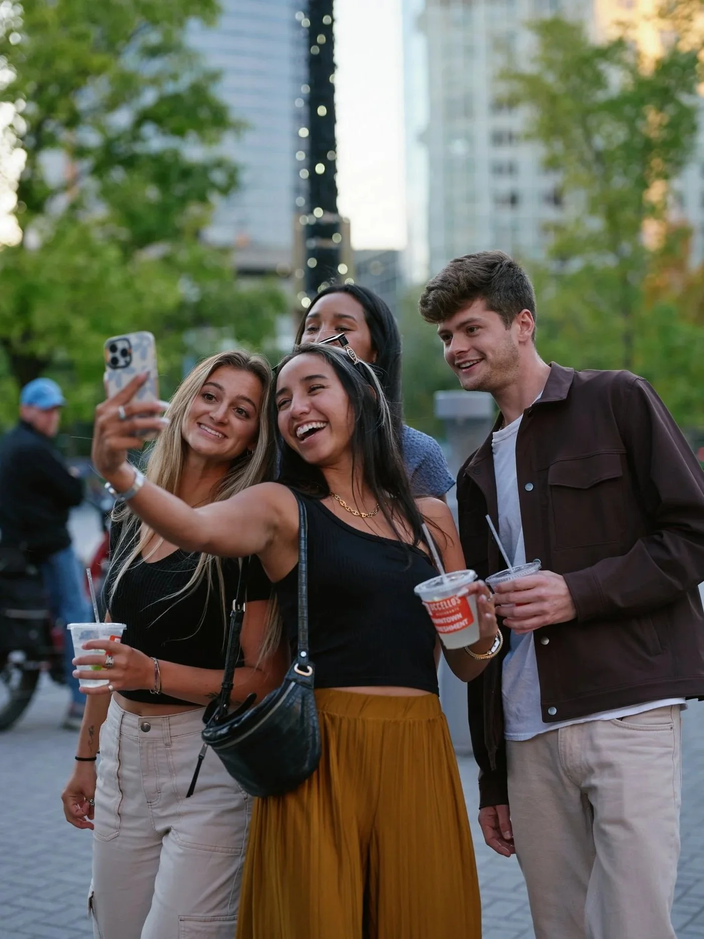 Young adults smiling and taking a selfie on a phone during ArtPrize in downtown Grand Rapids.